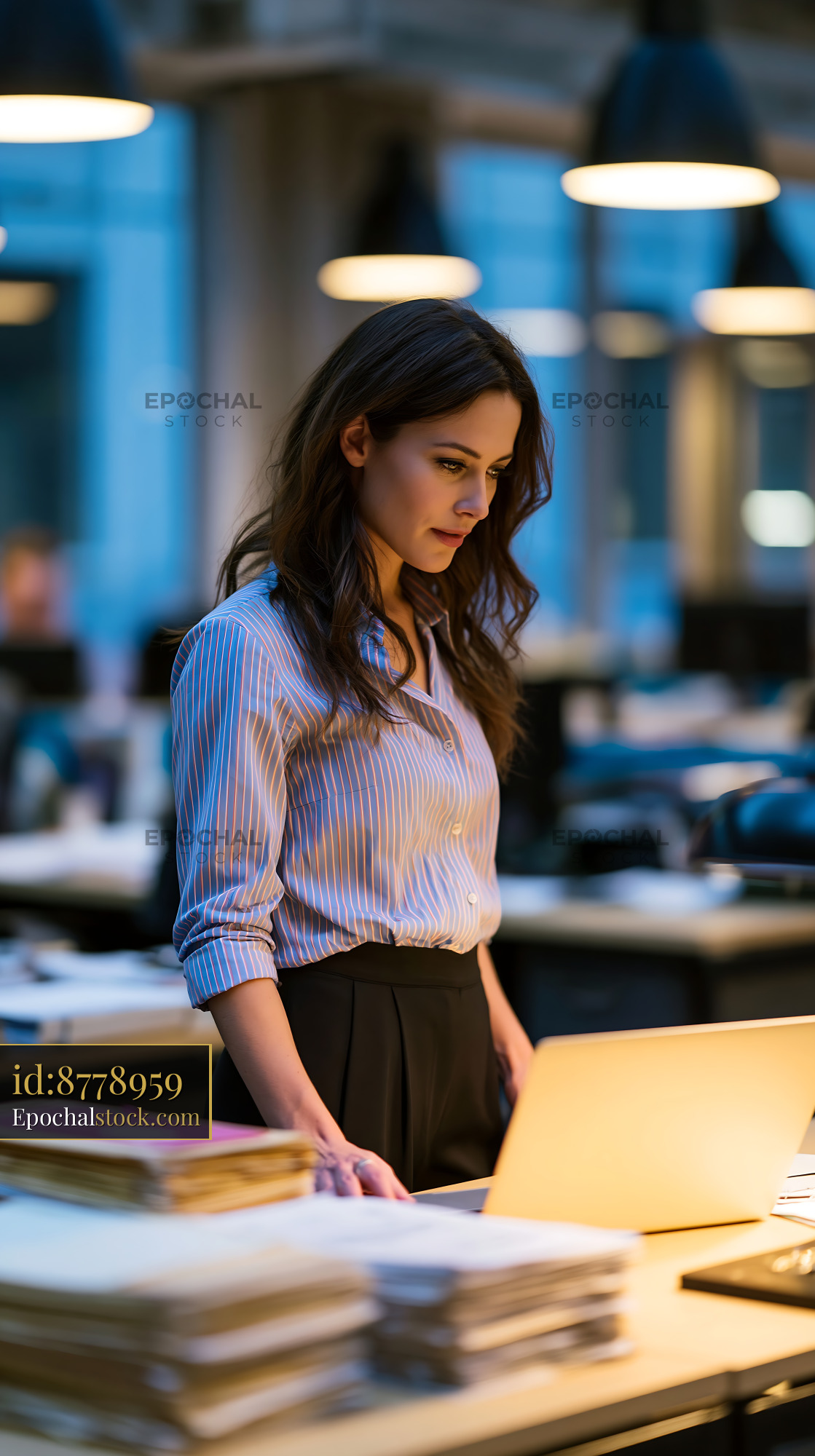 Watermarked full-resolution preview of Woman working at a computer in a modern office environment
