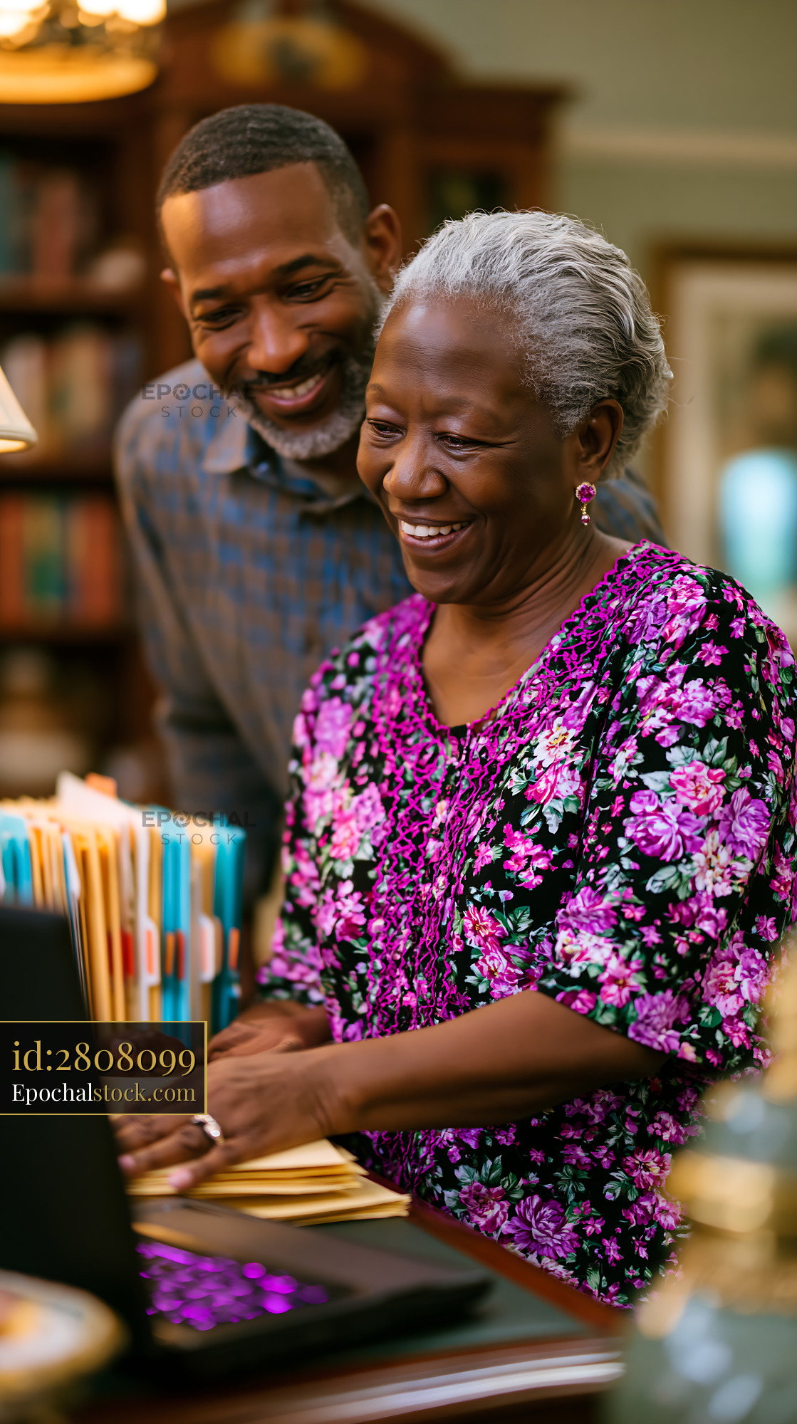 Watermarked full-resolution preview of Couple sharing joyful moment while working on a laptop at home