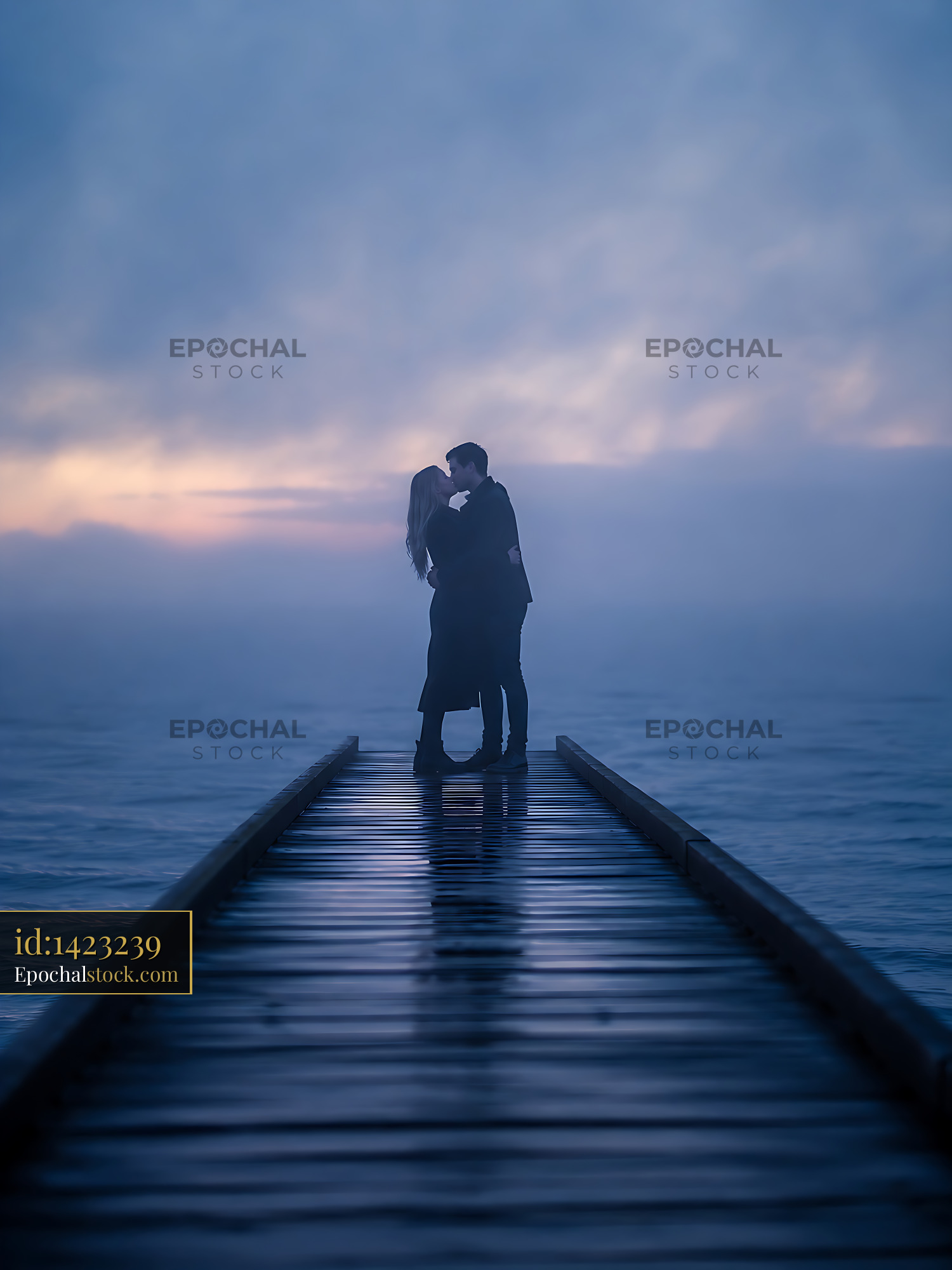 Watermarked full-resolution preview of Couple kissing on wooden pier during foggy sunset