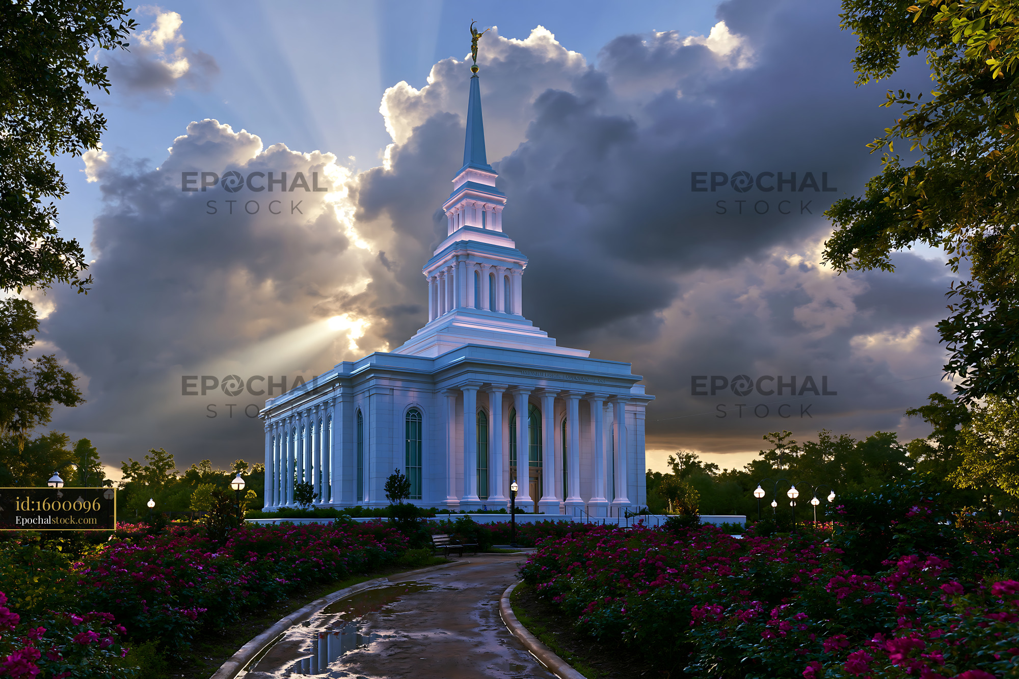 Watermarked full-resolution preview of Bright sunlight shines on a temple in a city park with flowers