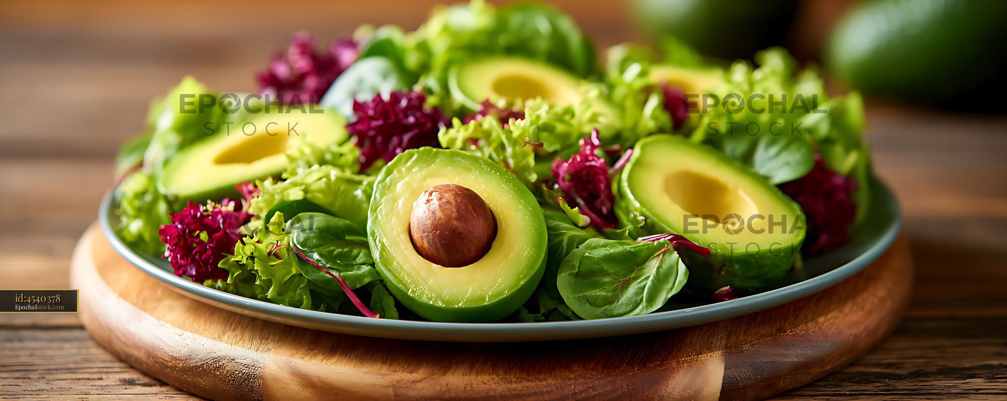 Watermarked full-resolution preview of Colorful leafy salad with fresh avocado on wooden board