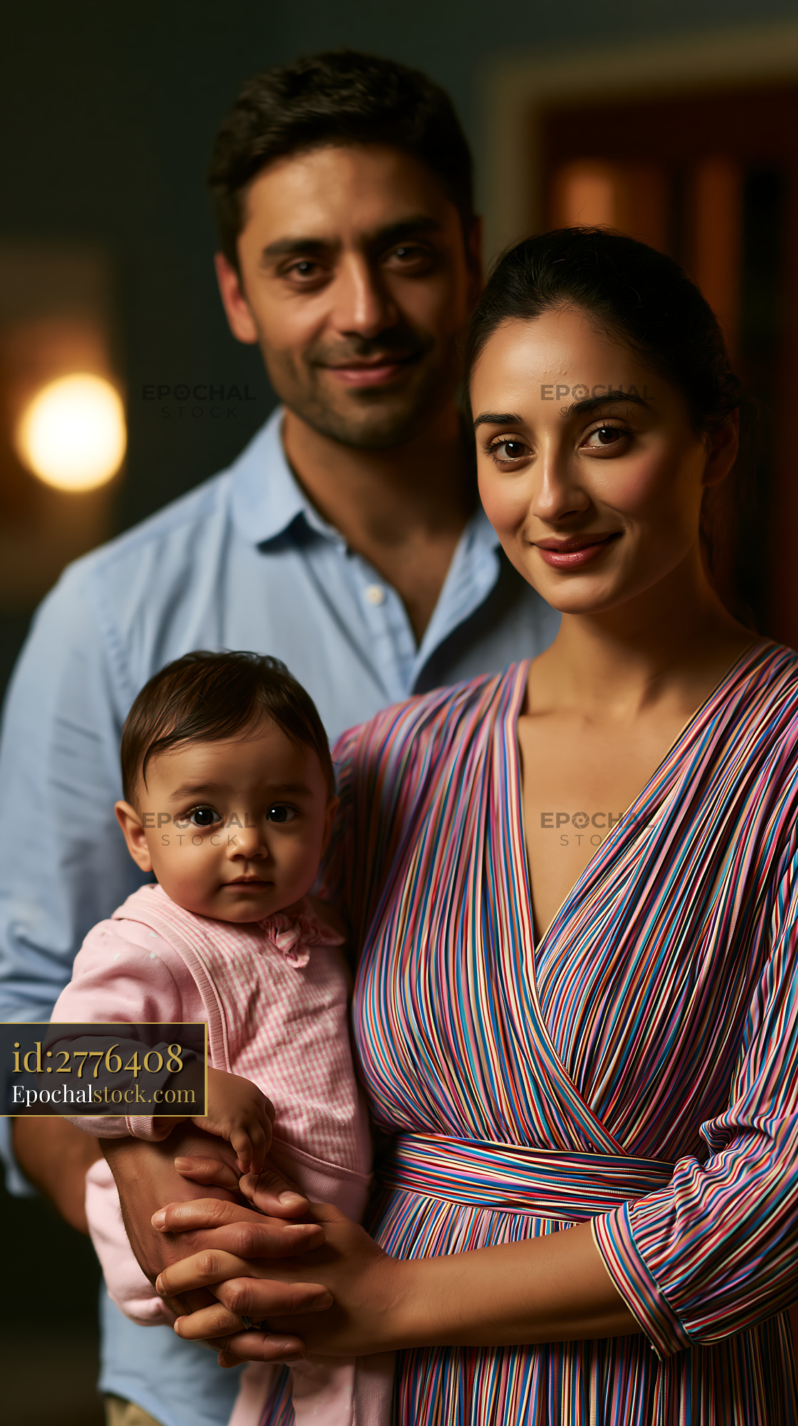 Watermarked full-resolution preview of Family portrait with parents holding baby indoors