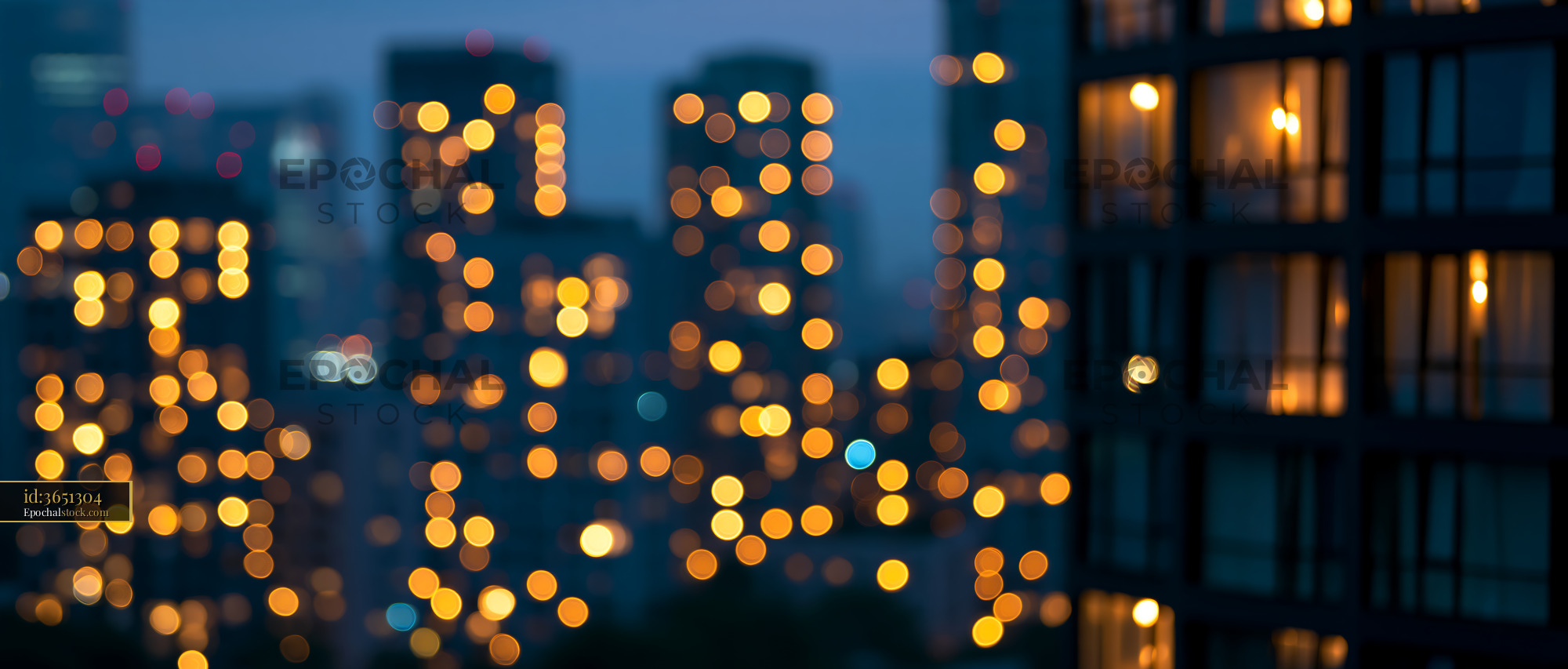 Watermarked full-resolution preview of City skyline in evening with glowing lights