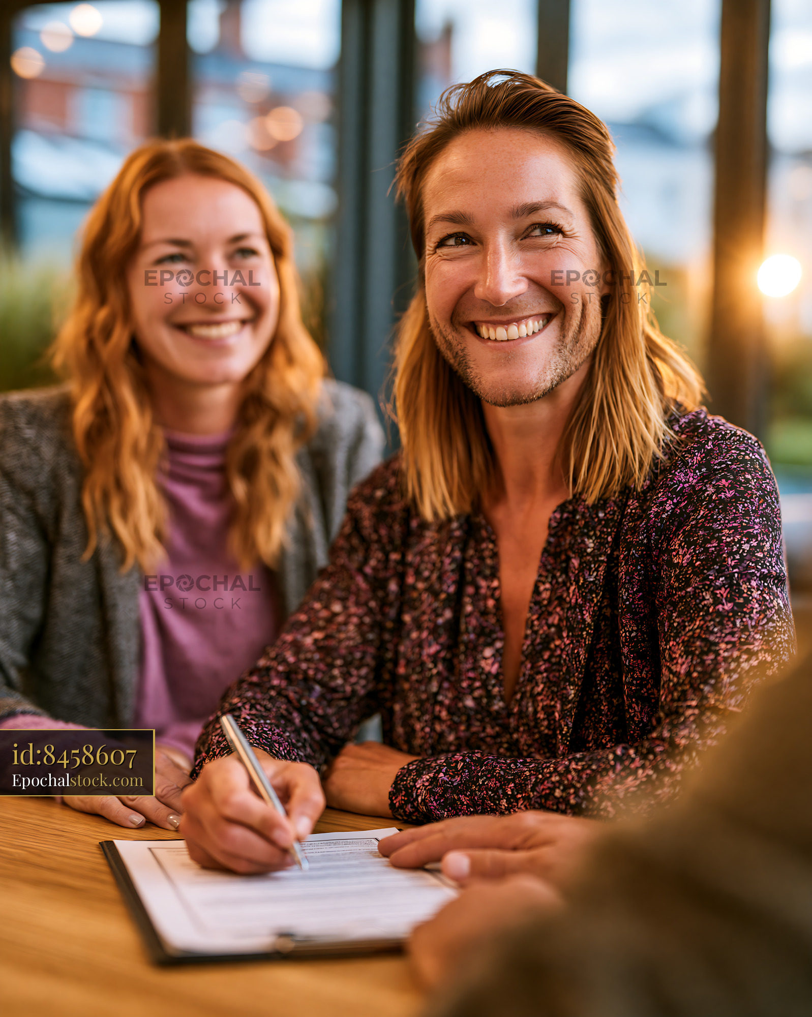 Watermarked full-resolution preview of People signing documents in modern cafe setting