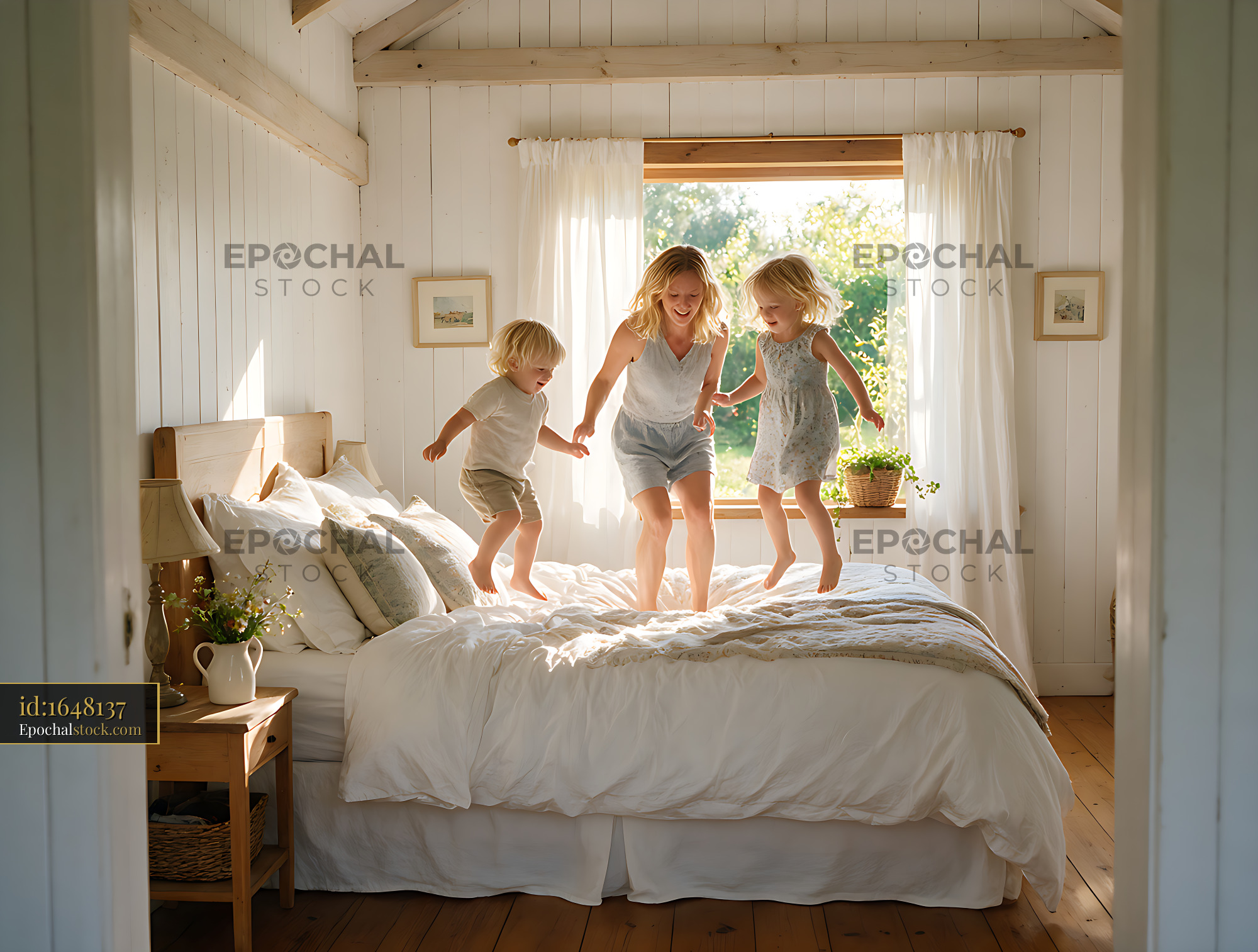 Watermarked full-resolution preview of Mother and children playing on bed in sunny bedroom