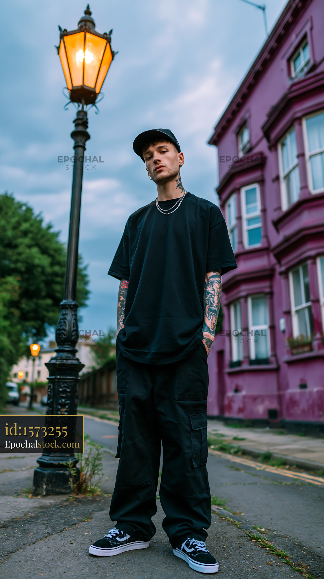 Watermarked full-resolution preview of Man standing near lamp post along street with pink building