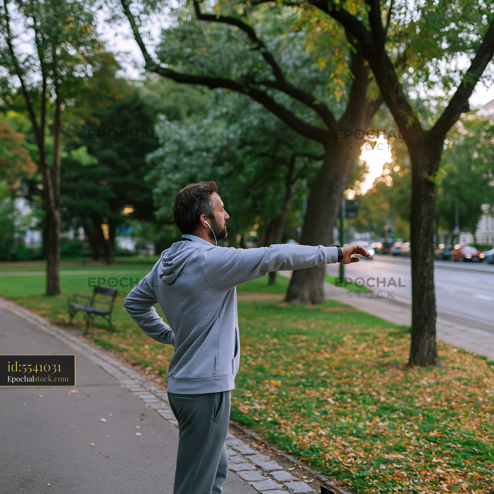Watermarked full-resolution preview of Man pointing while walking in a city park during autumn