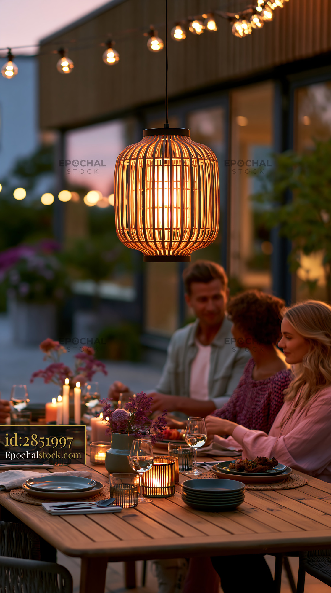 Watermarked full-resolution preview of Warm outdoor dining scene with pendant lighting