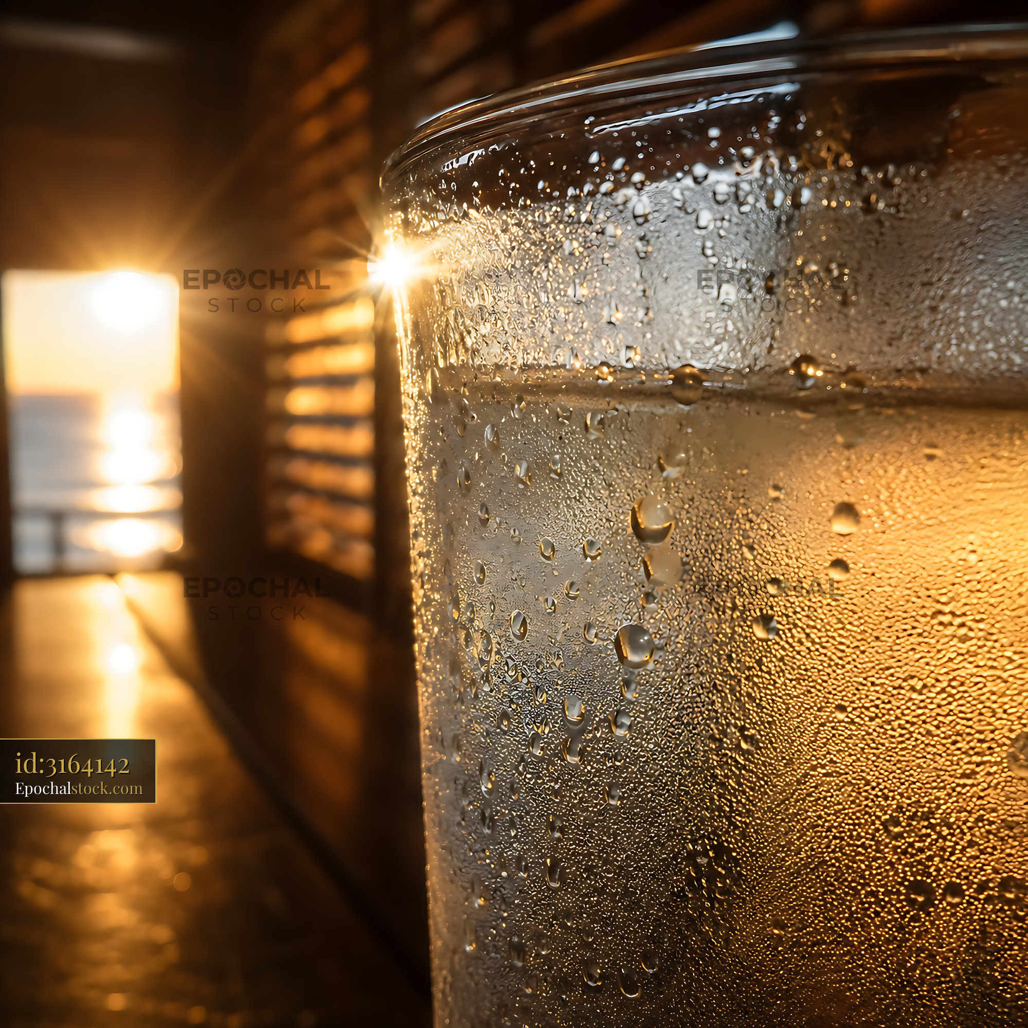 Watermarked full-resolution preview of Glass of water with condensation in front of sunset view