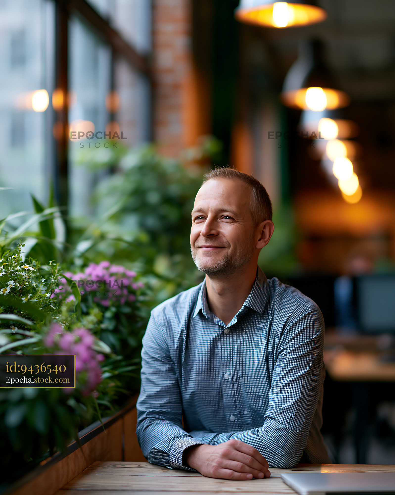 Watermarked full-resolution preview of Man sitting by a window with plants and flowers in a cafe