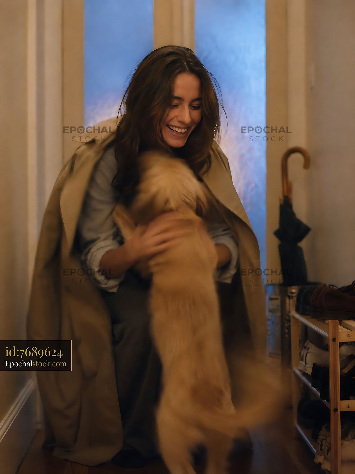 Watermarked full-resolution preview of Woman playing with dog inside home during winter evening