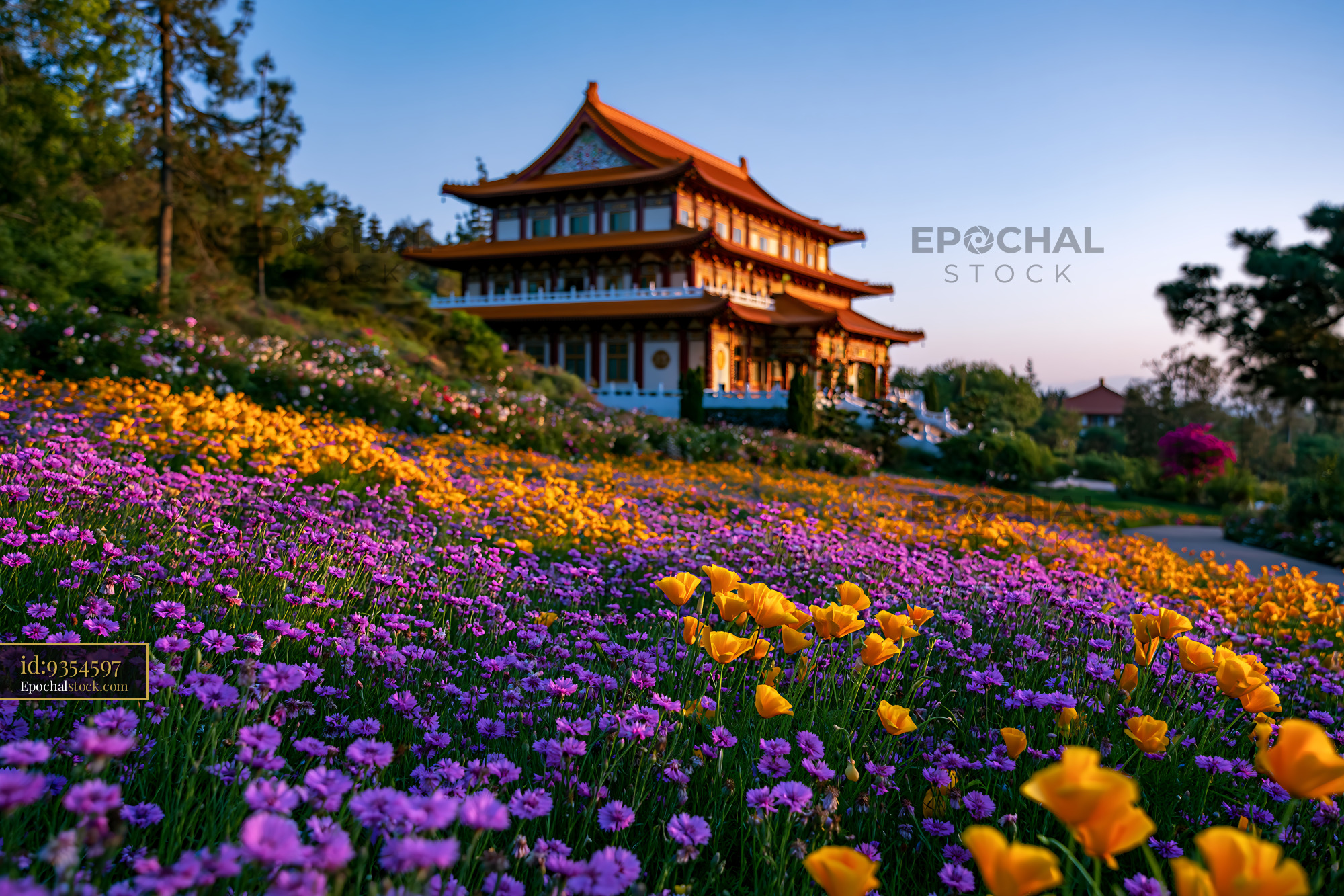 Watermarked full-resolution preview of Flowers surround a traditional building at sunset in a garden
