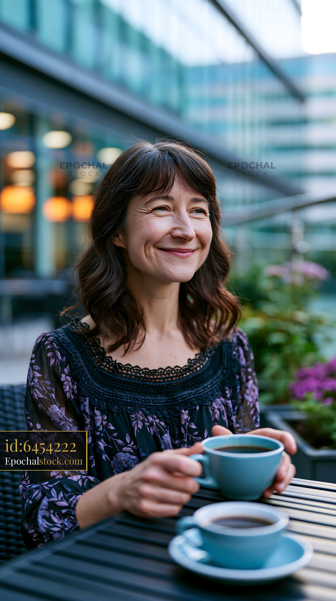 Smiling Woman Enjoying Coffee Outdoors at a Cafe - stock photo