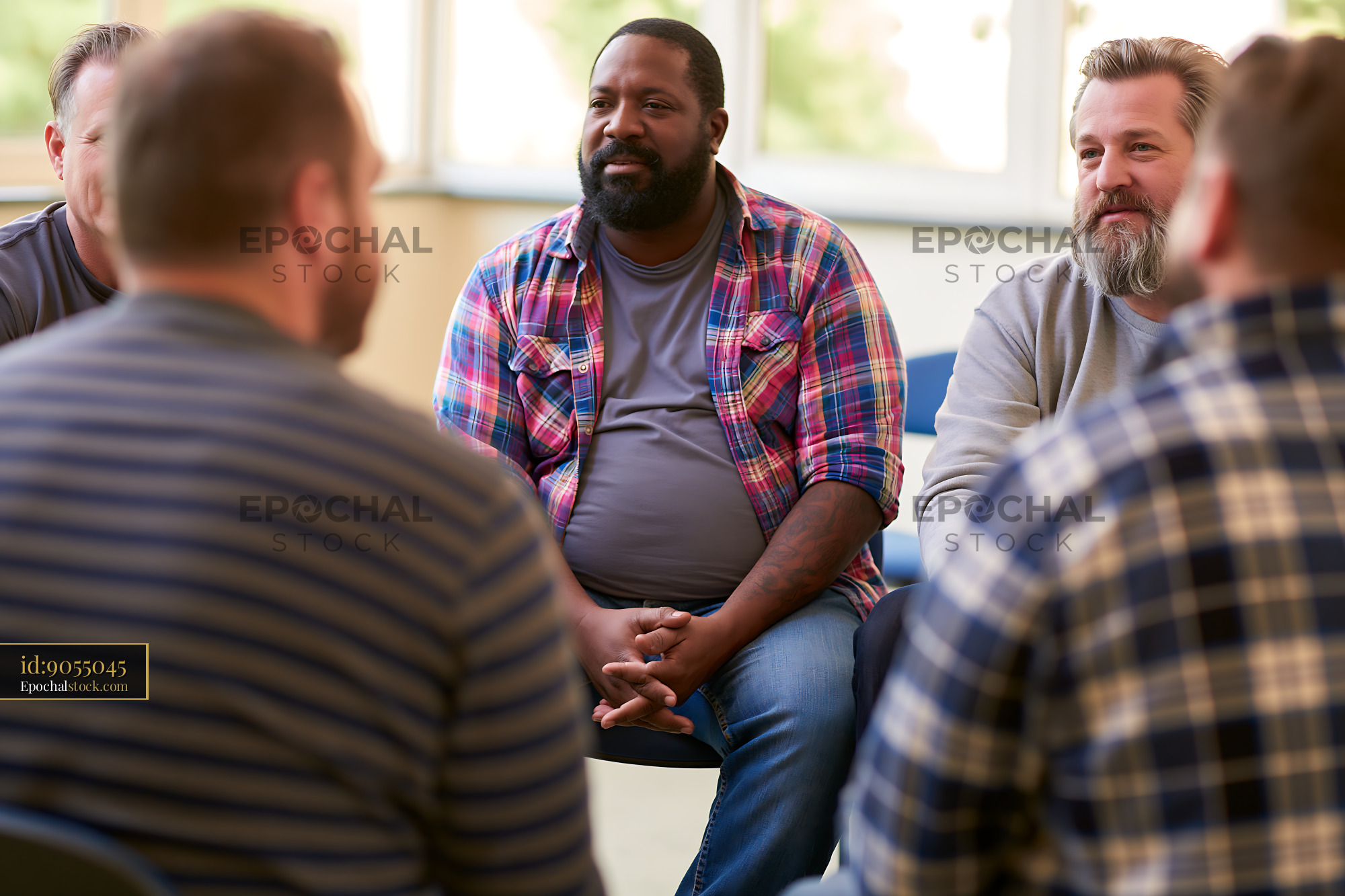 Watermarked full-resolution preview of Group of men engaged in conversation in a meeting room