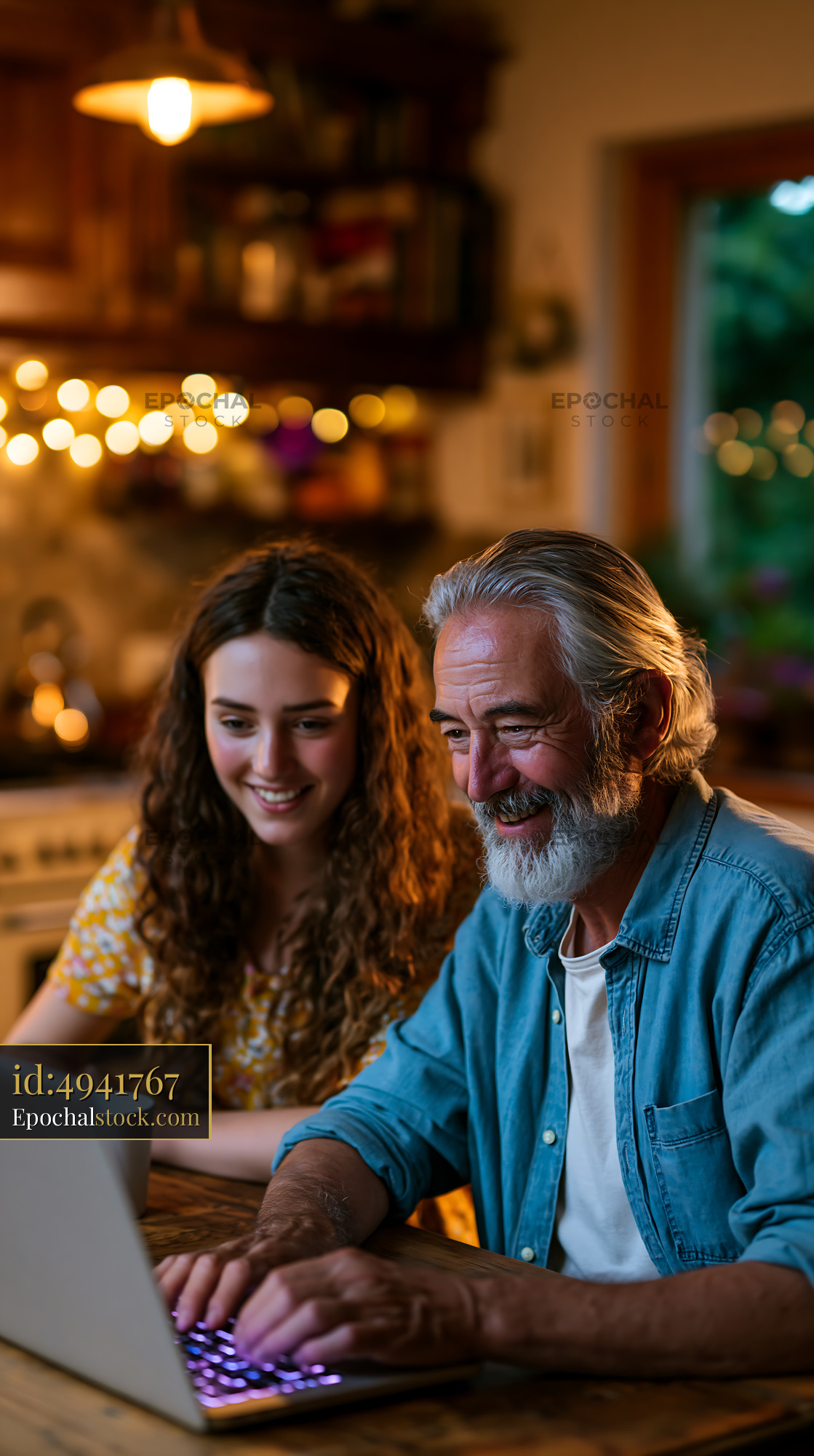 Watermarked full-resolution preview of Two people working together on a laptop in a cozy kitchen