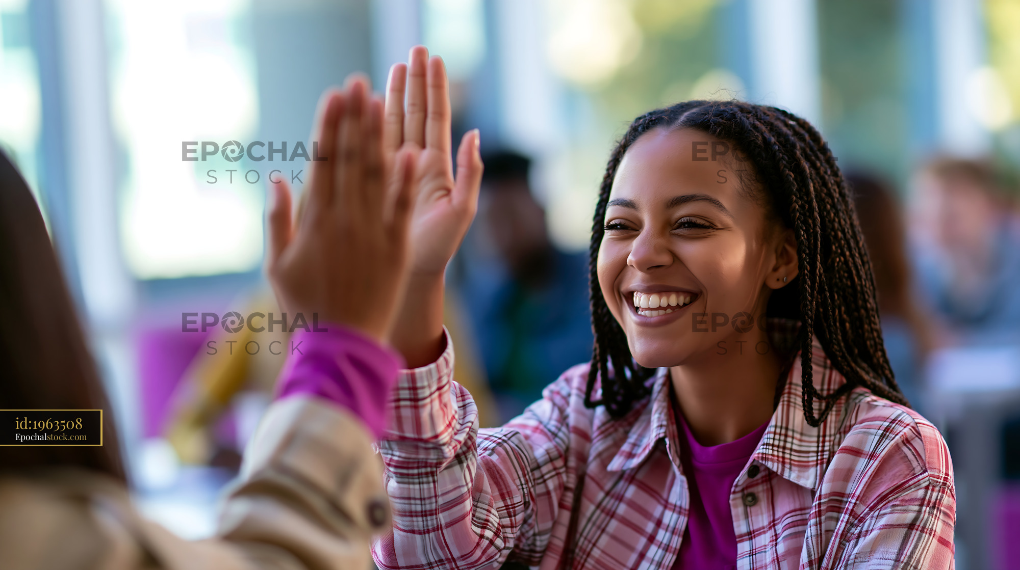 Watermarked full-resolution preview of Two people sharing a high five in a modern indoor setting