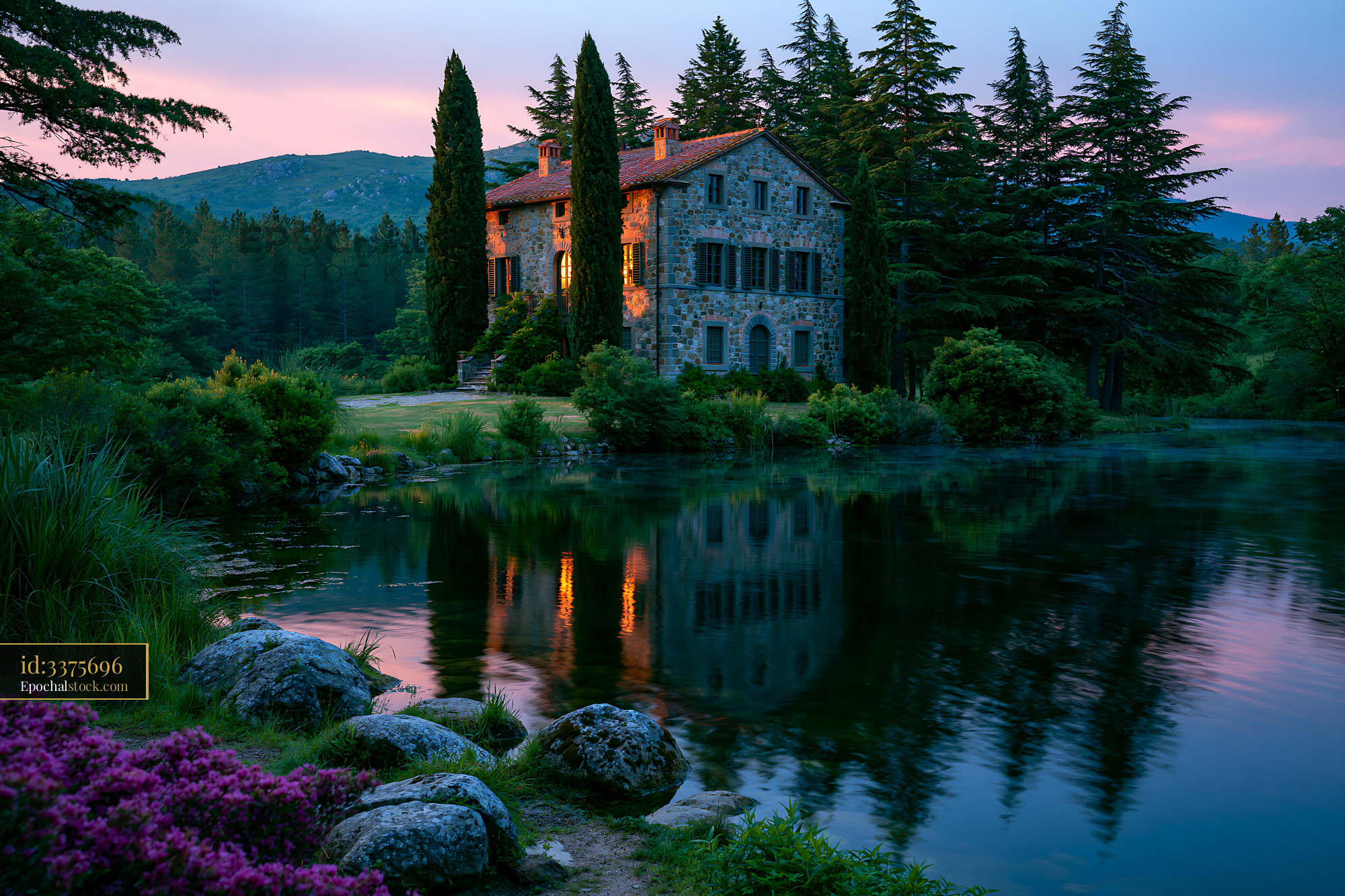 Watermarked full-resolution preview of Stone house by the lake surrounded by trees at twilight