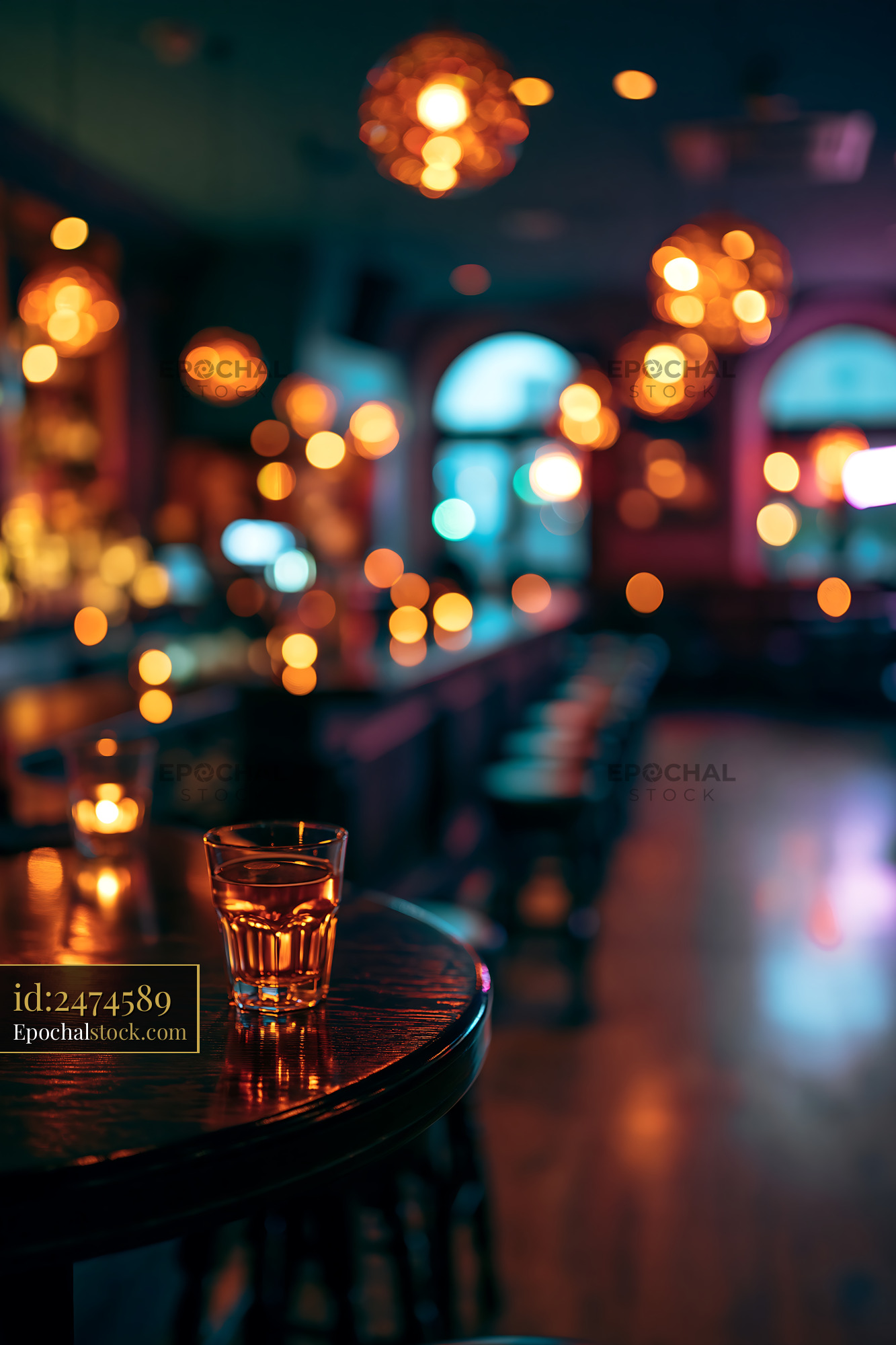 Watermarked full-resolution preview of Glass of whiskey on wooden table in dimly lit bar
