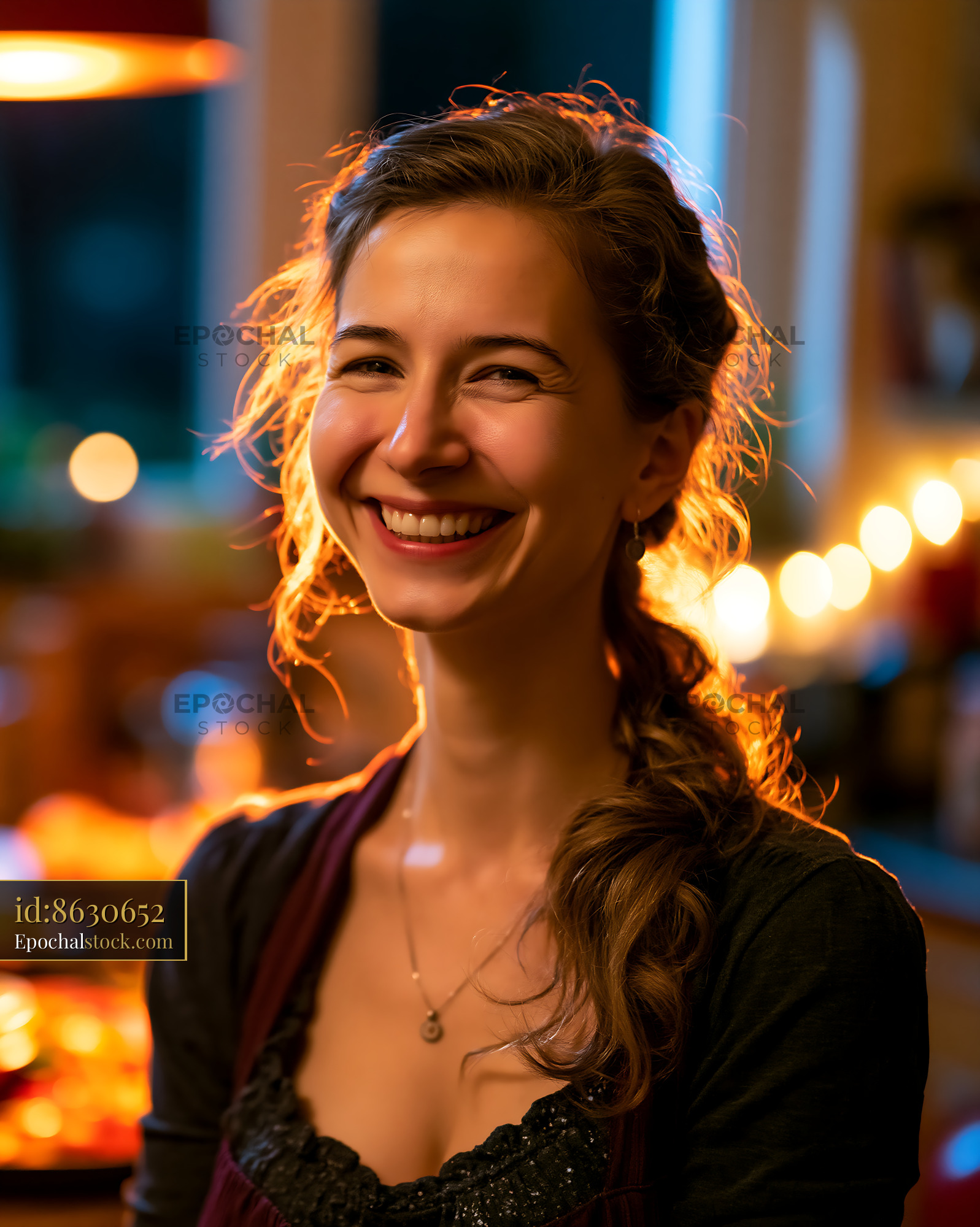 Watermarked full-resolution preview of Smiling woman in kitchen with warm lights at evening