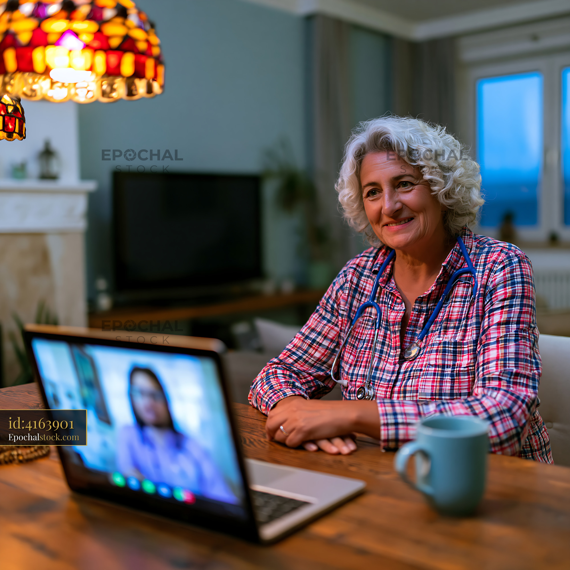 Watermarked full-resolution preview of Elderly woman enjoys video call at home during evening