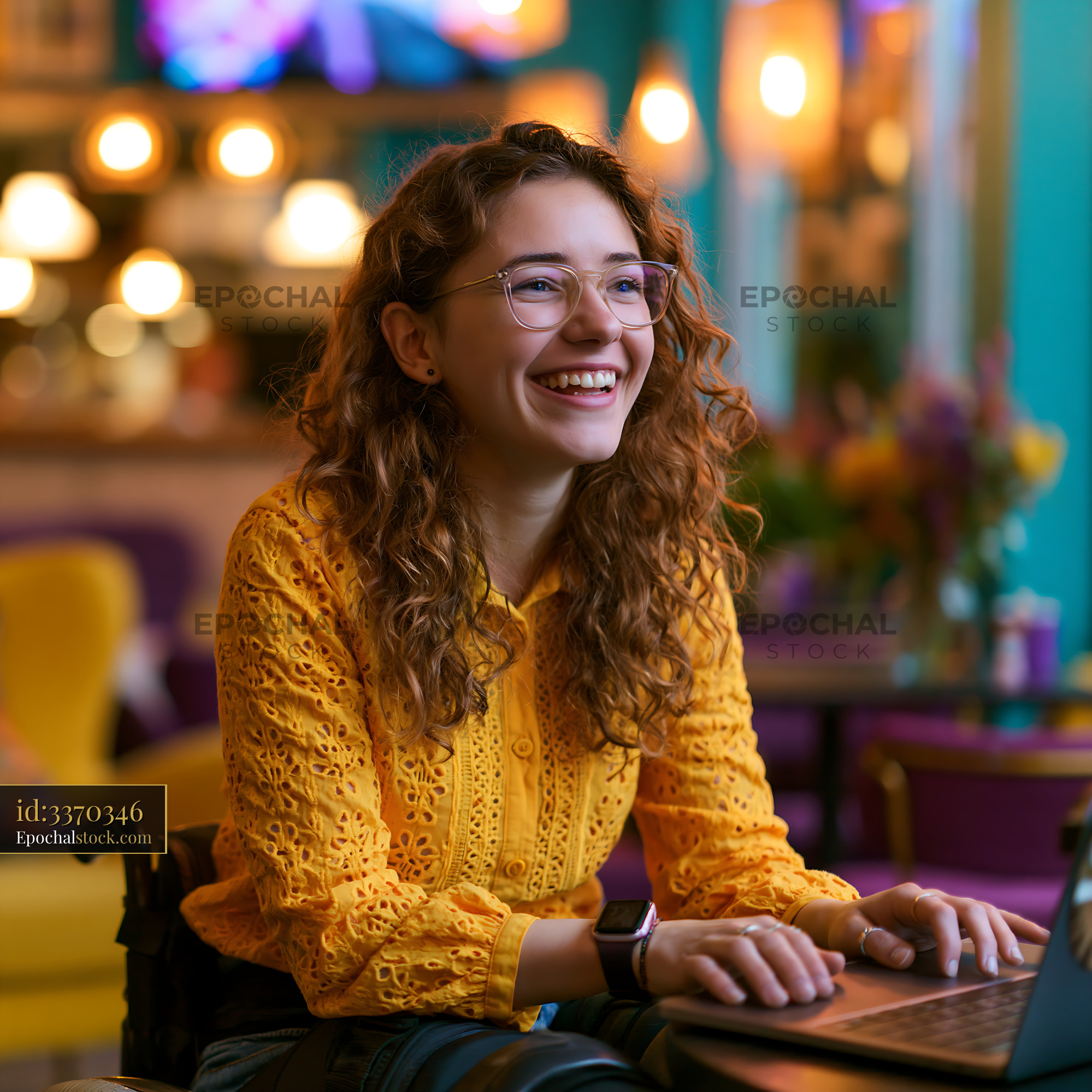 Laughing Student Using Laptop in Cafe With Bright Colors - stock photo
