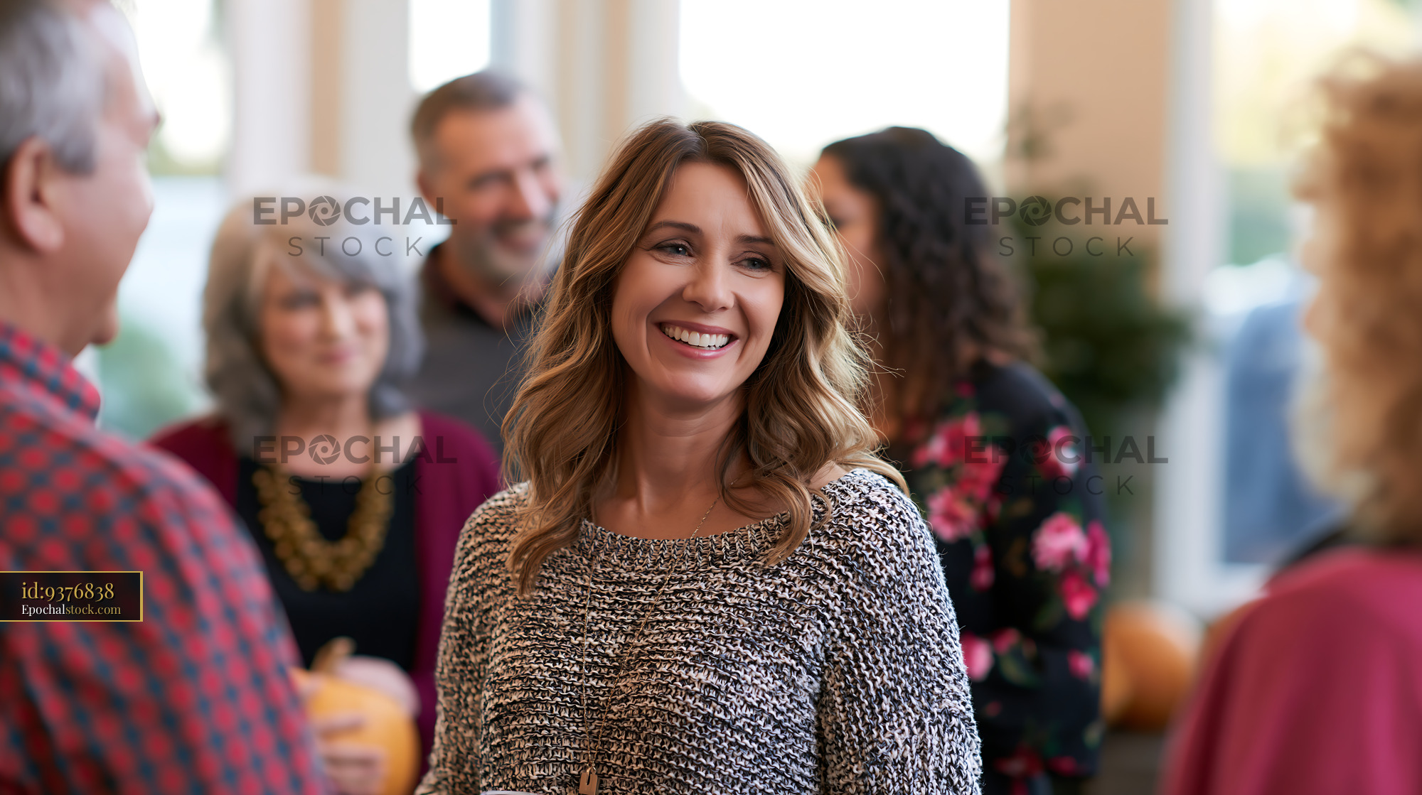 Watermarked full-resolution preview of People socialize and laugh at a gathering during autumn