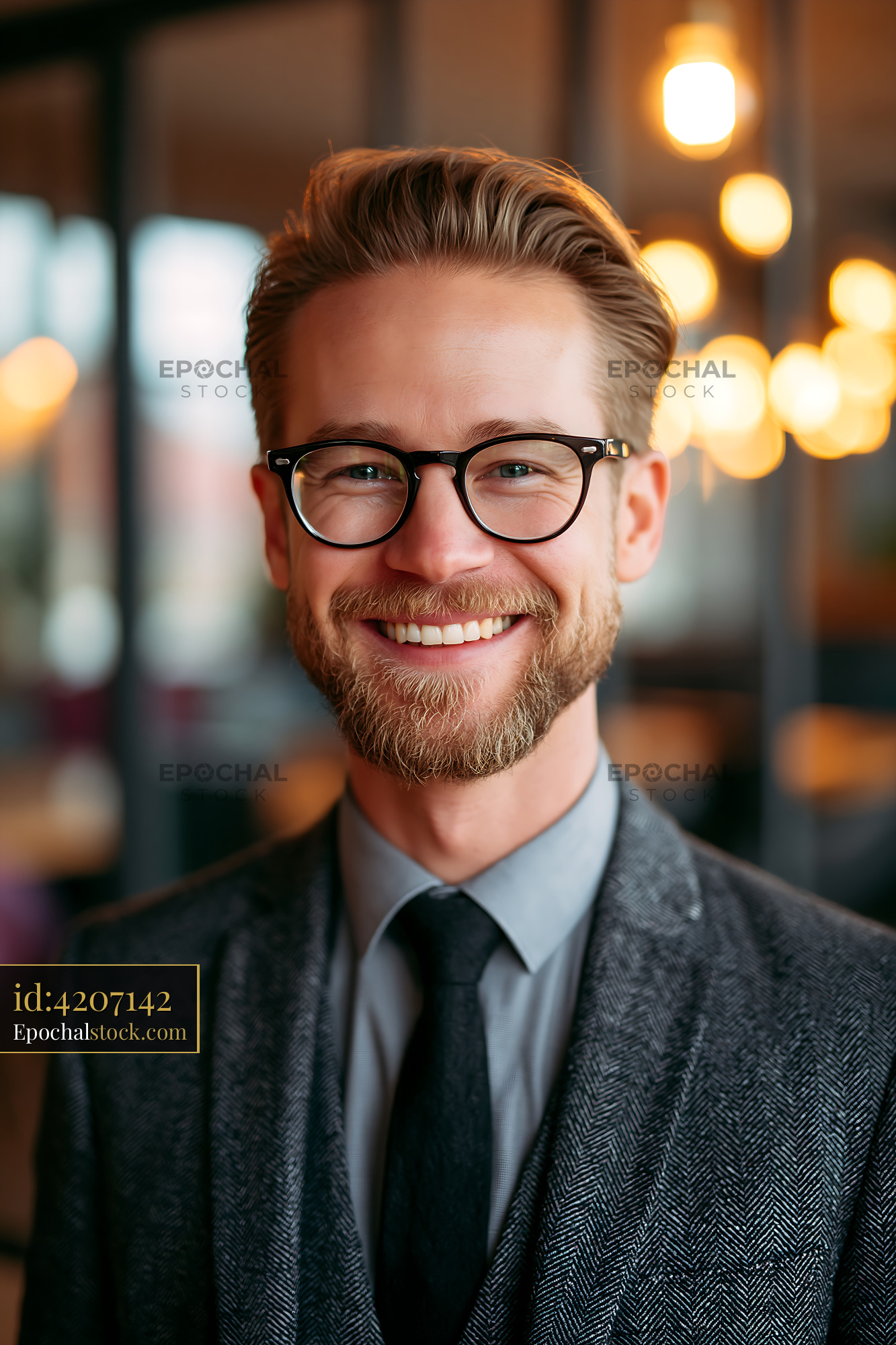 Watermarked full-resolution preview of Man smiles in a stylish suit against a warm, lit background