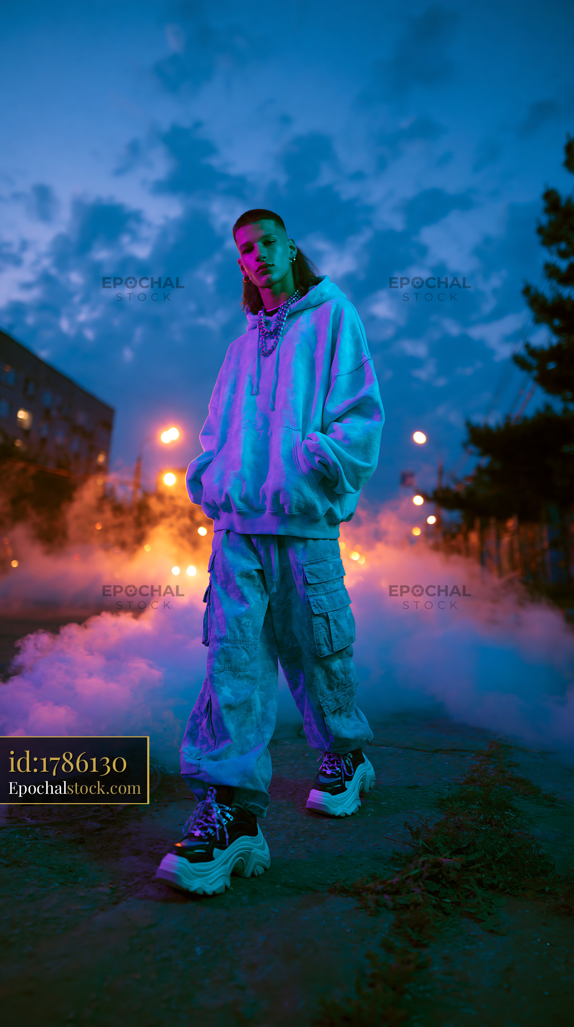 Watermarked full-resolution preview of Person standing on street surrounded by fog at dusk
