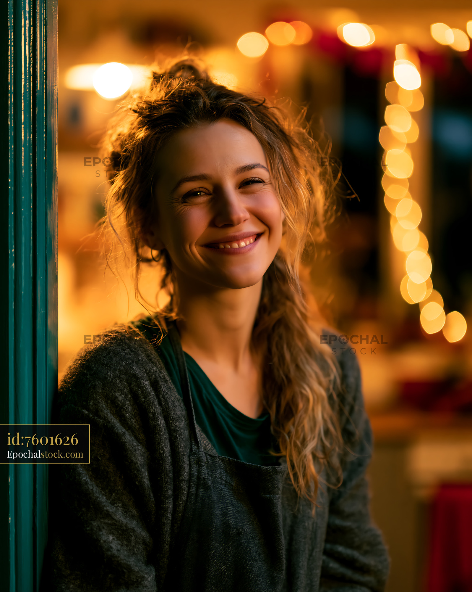 Person Smiles While Standing in Warm, Cozy Indoor Setting - stock photo
