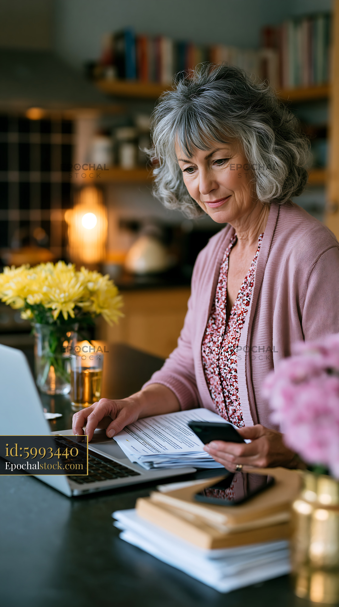 Watermarked full-resolution preview of Woman working on laptop at home office table