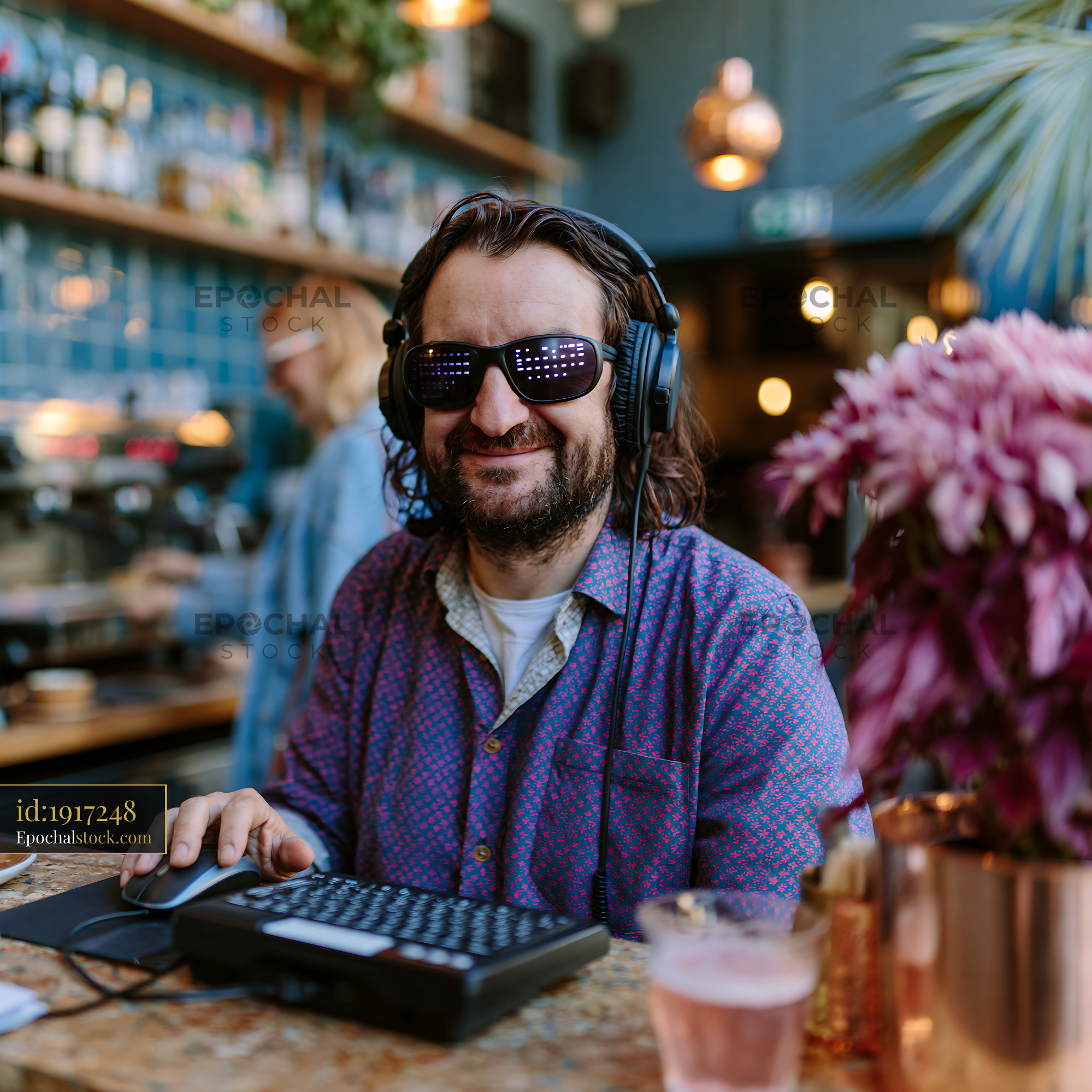 Watermarked full-resolution preview of Man working at a cafe with headphones and sunglasses in the afternoon