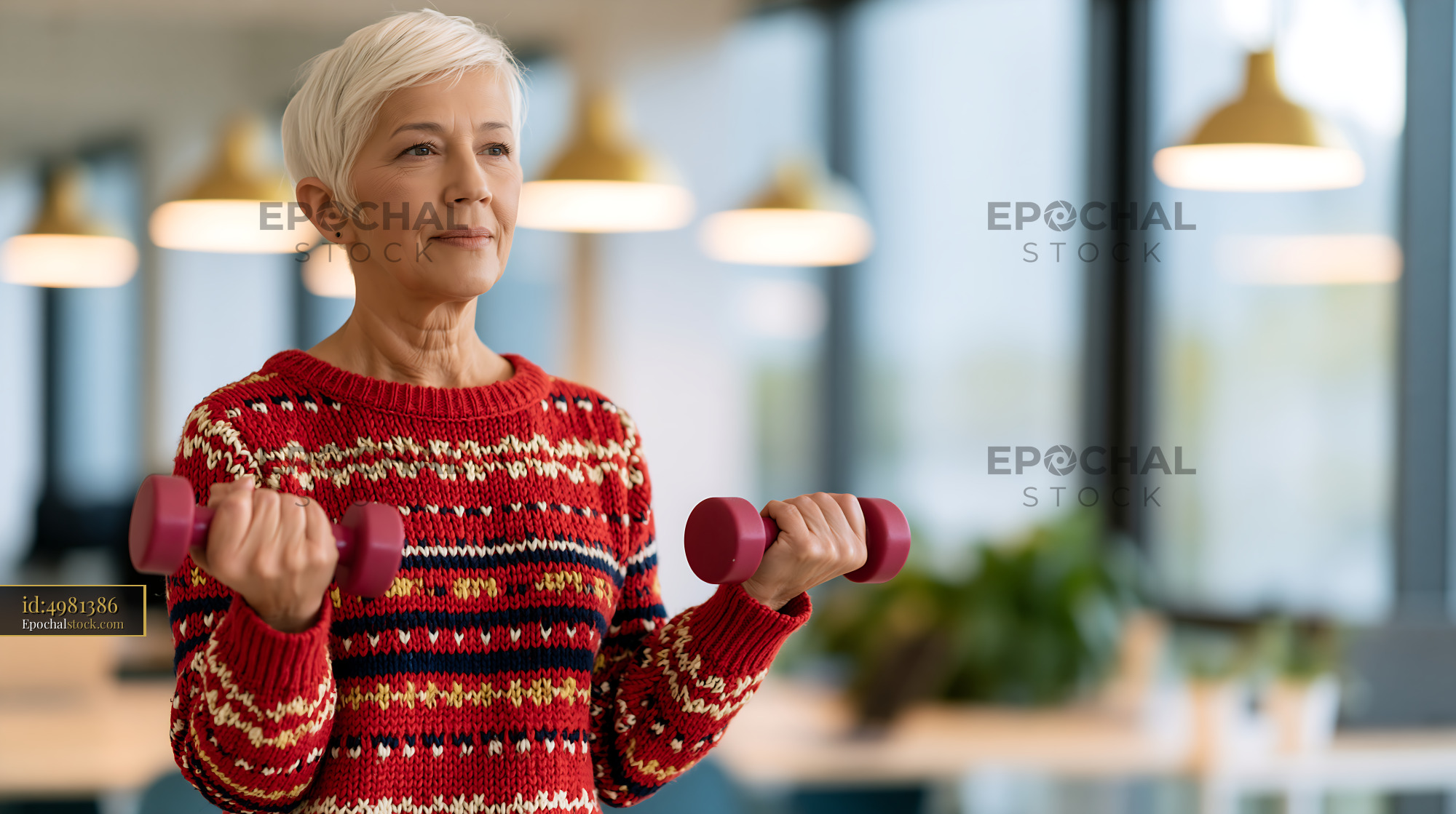 Watermarked full-resolution preview of Older woman exercising with dumbbells in a bright gym setting