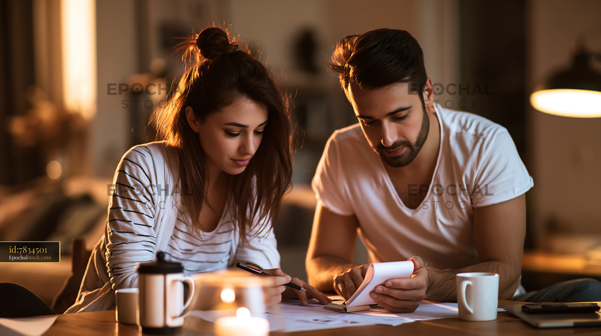 Watermarked full-resolution preview of Couple working together on a project at a cozy home setting