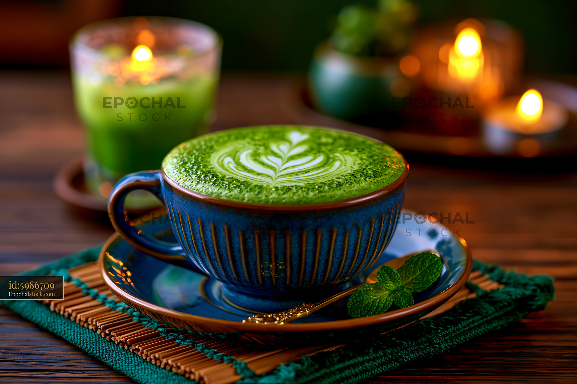 Watermarked full-resolution preview of Matcha latte in blue cup with leaves and candles on wooden table