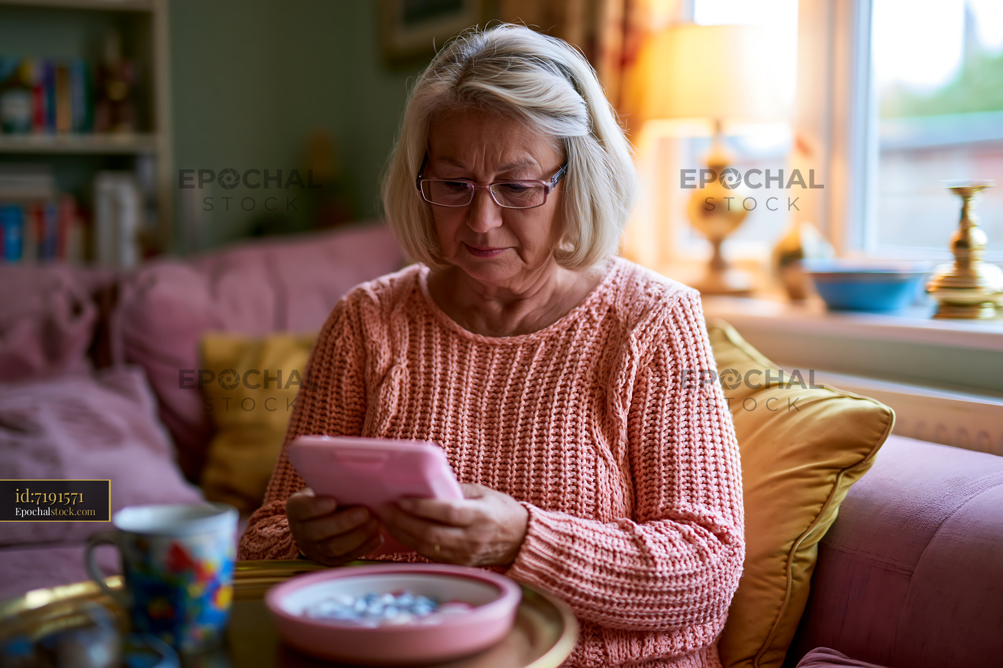 Watermarked full-resolution preview of Senior woman reading a smartphone in a cozy living room