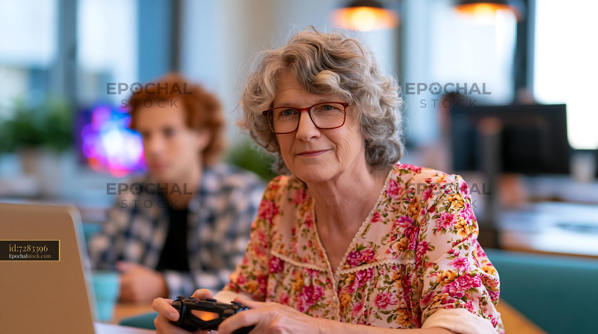 Watermarked full-resolution preview of Older woman playing video games in a modern workspace