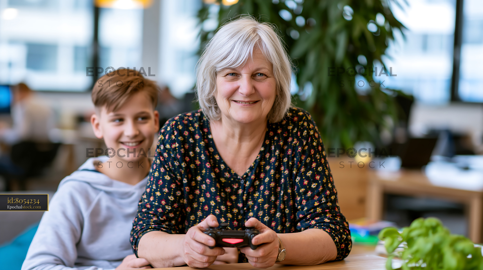 Older Woman Gaming With Grandson in a Modern Workspace - stock photo