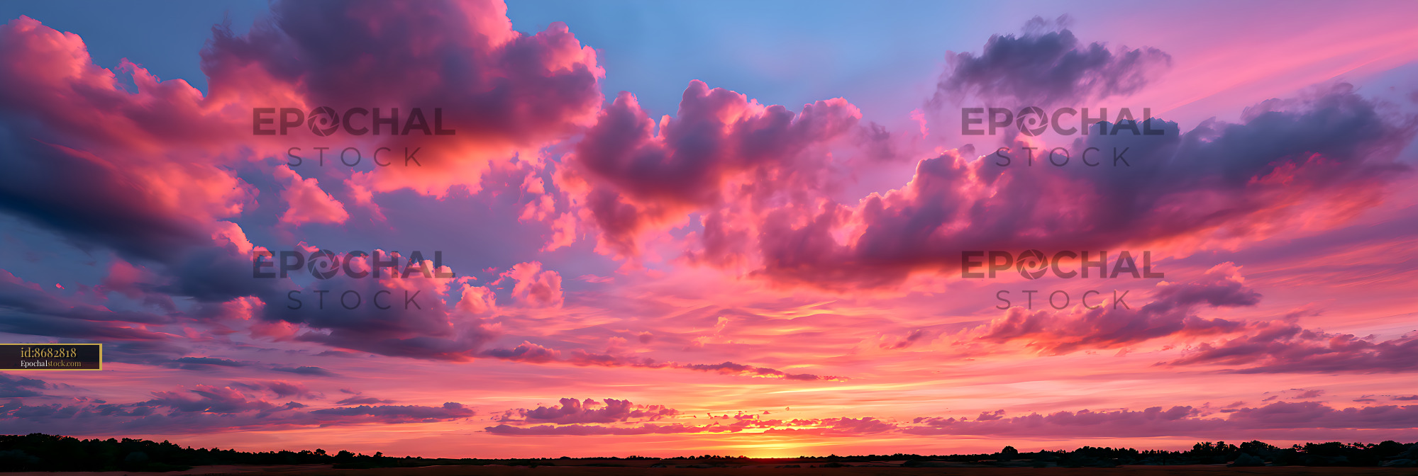 Vivid pink sunset over dramatic clouds and dark horizon