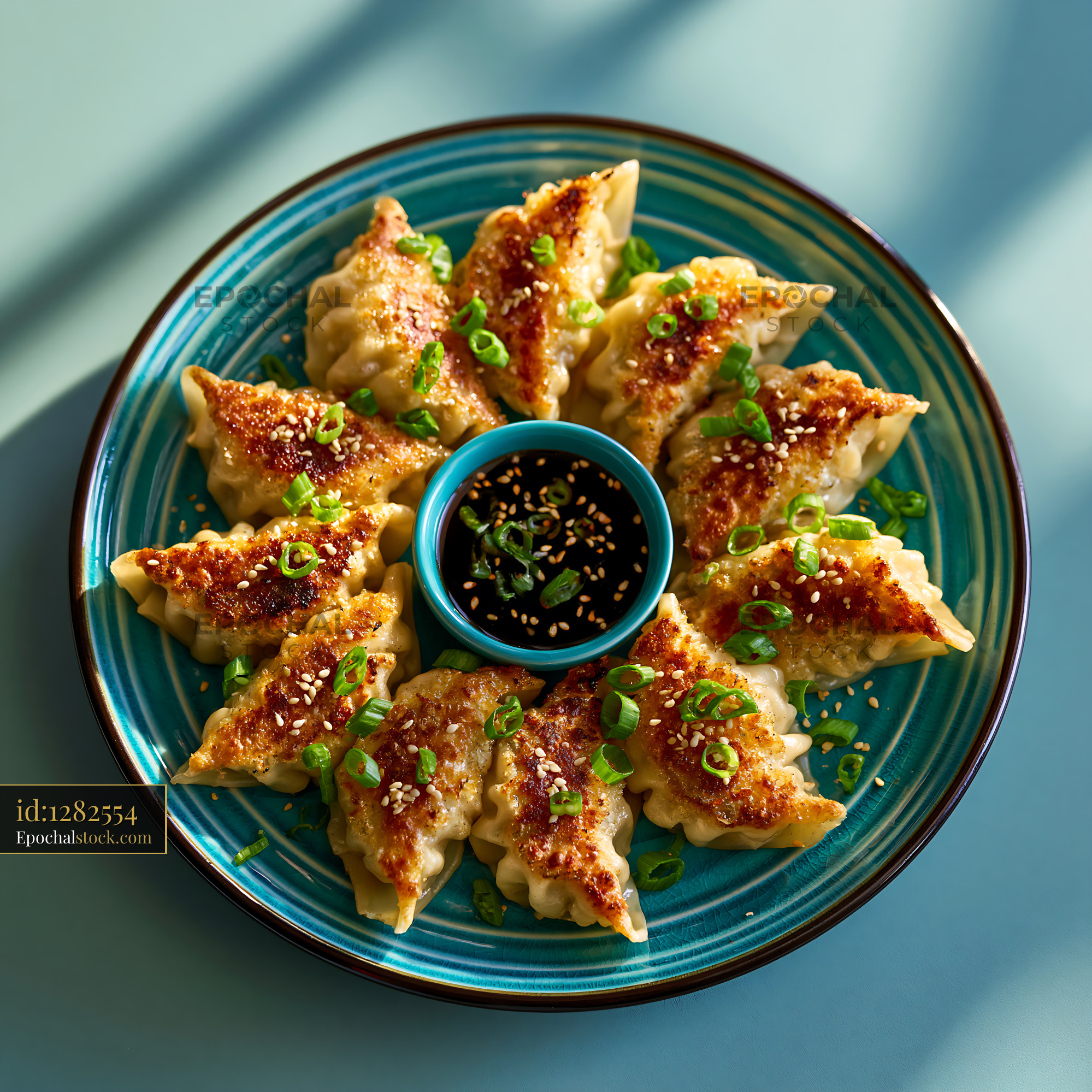 Watermarked full-resolution preview of Dumplings served with dipping sauce on a blue plate