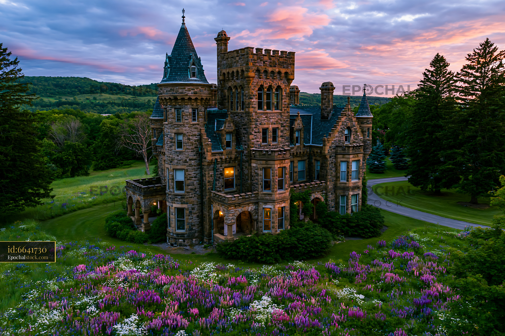 Watermarked full-resolution preview of Historic stone castle surrounded by wildflowers at sunset