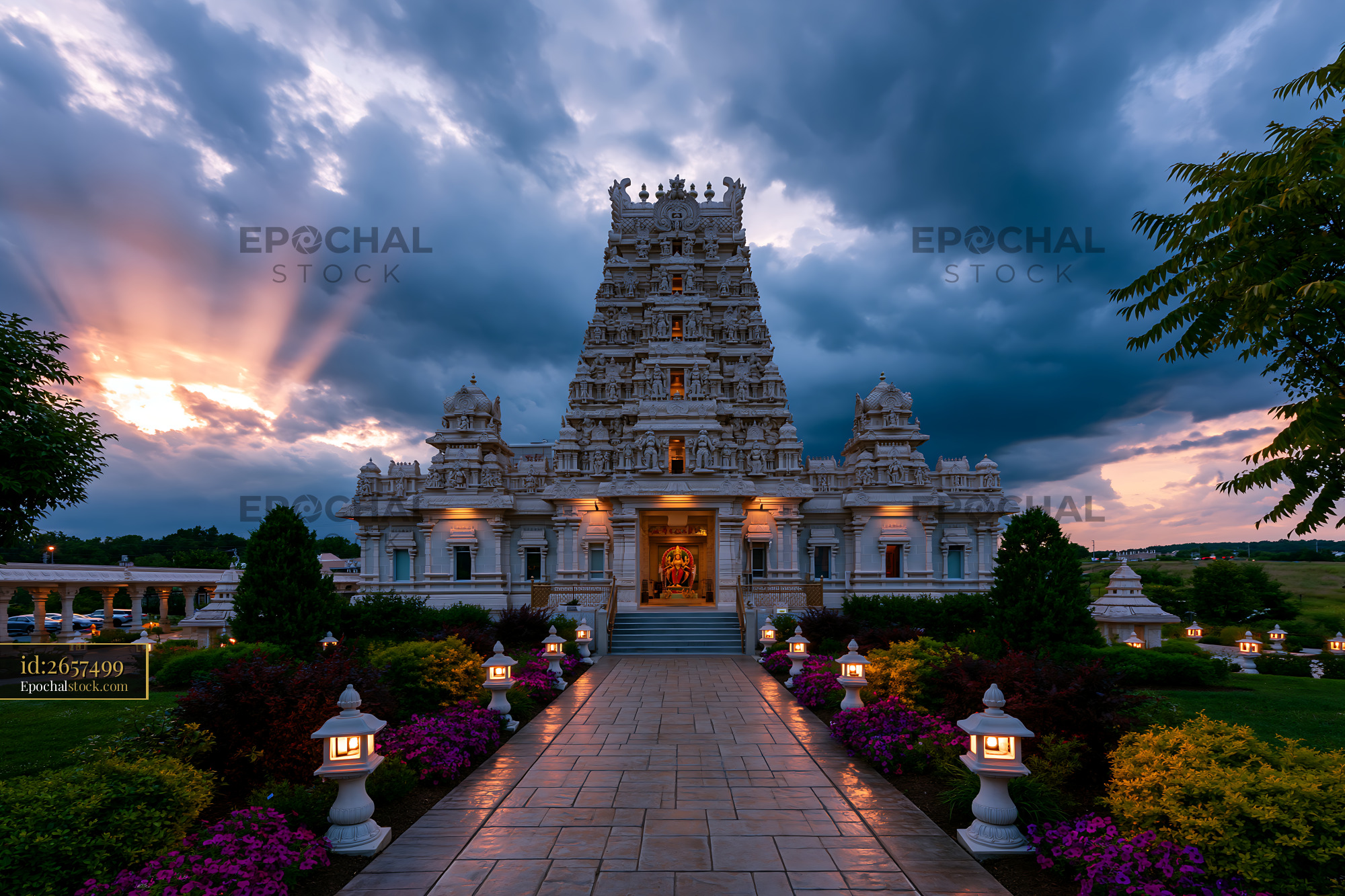 Watermarked full-resolution preview of Illuminated Hindu temple and garden at dramatic sunset