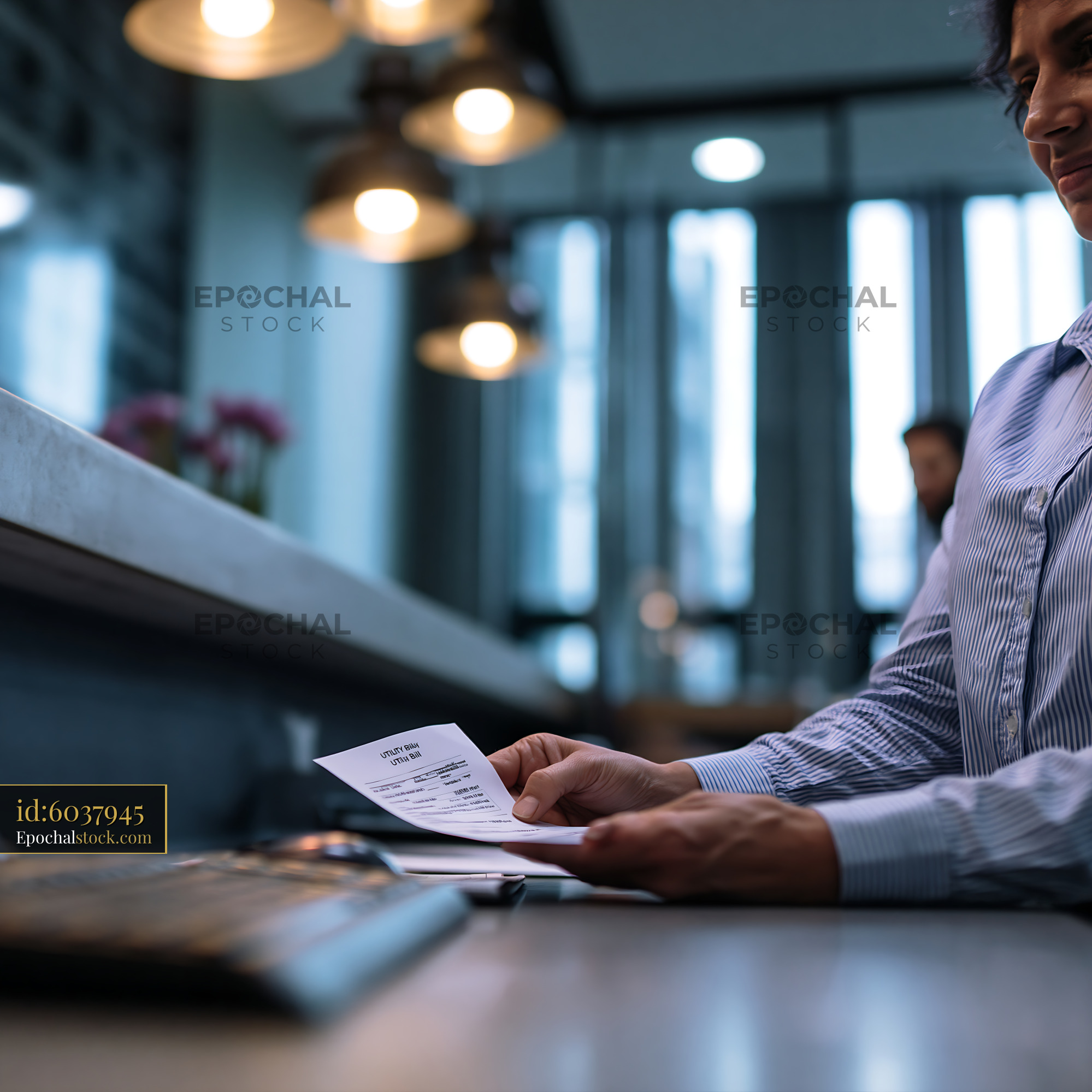 Watermarked full-resolution preview of Person looking at a receipt in a cafe setting