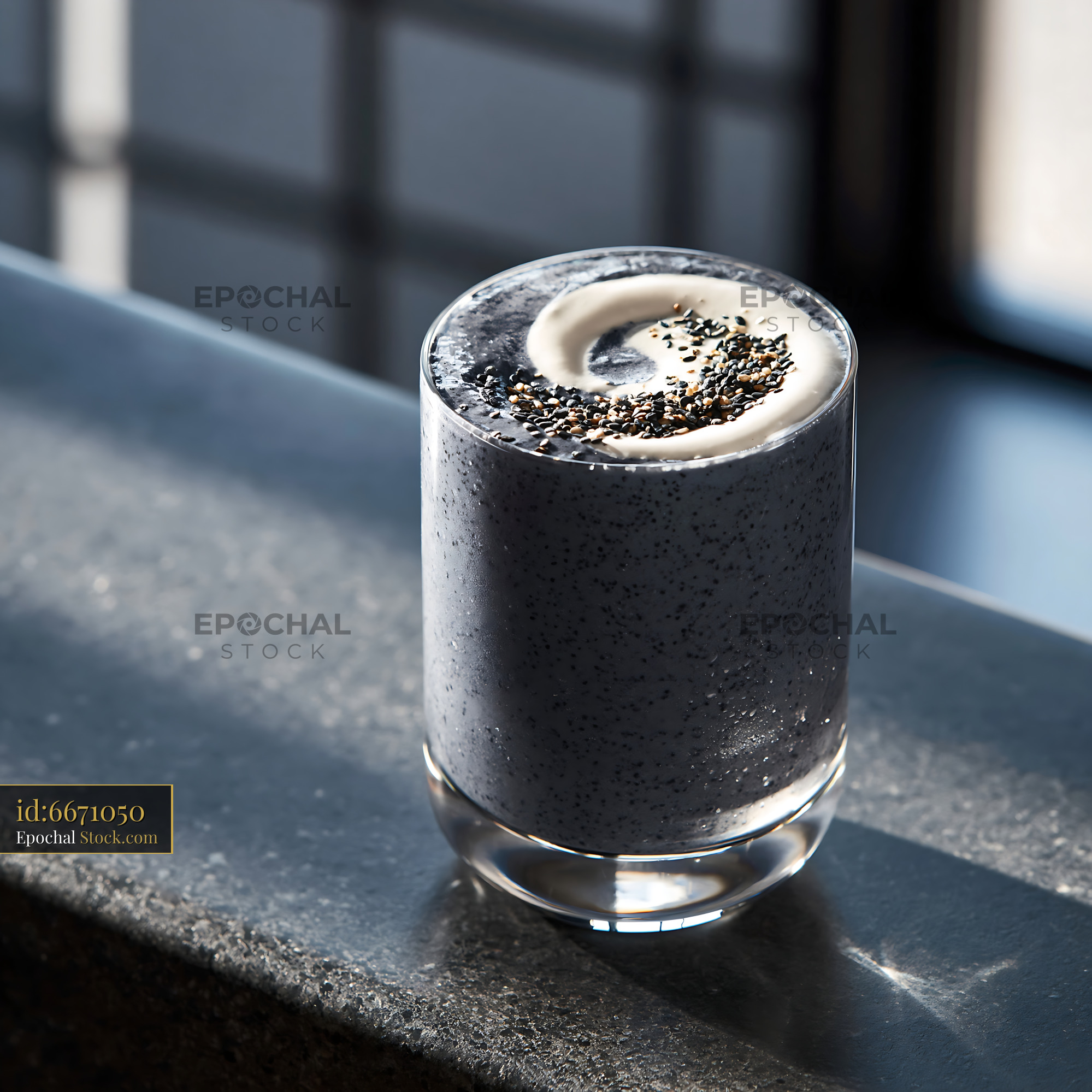 Black sesame kurogoma smoothie with cream swirl on a stone ledge - stock photo