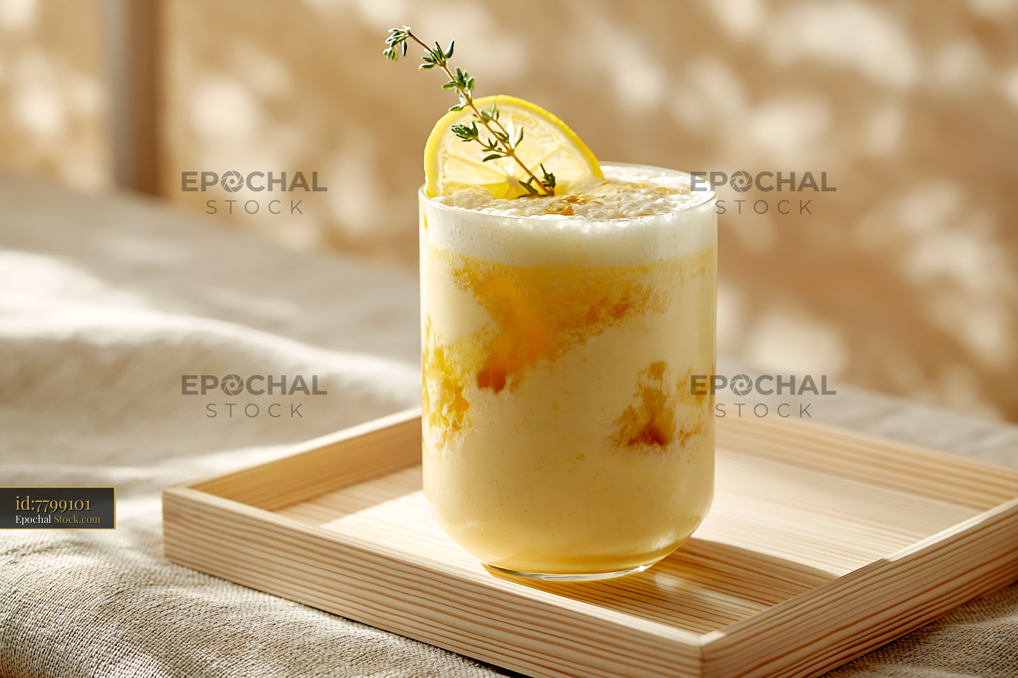 Refreshing yuzu honey smoothie on a wooden tray in soft sunlight - stock photo