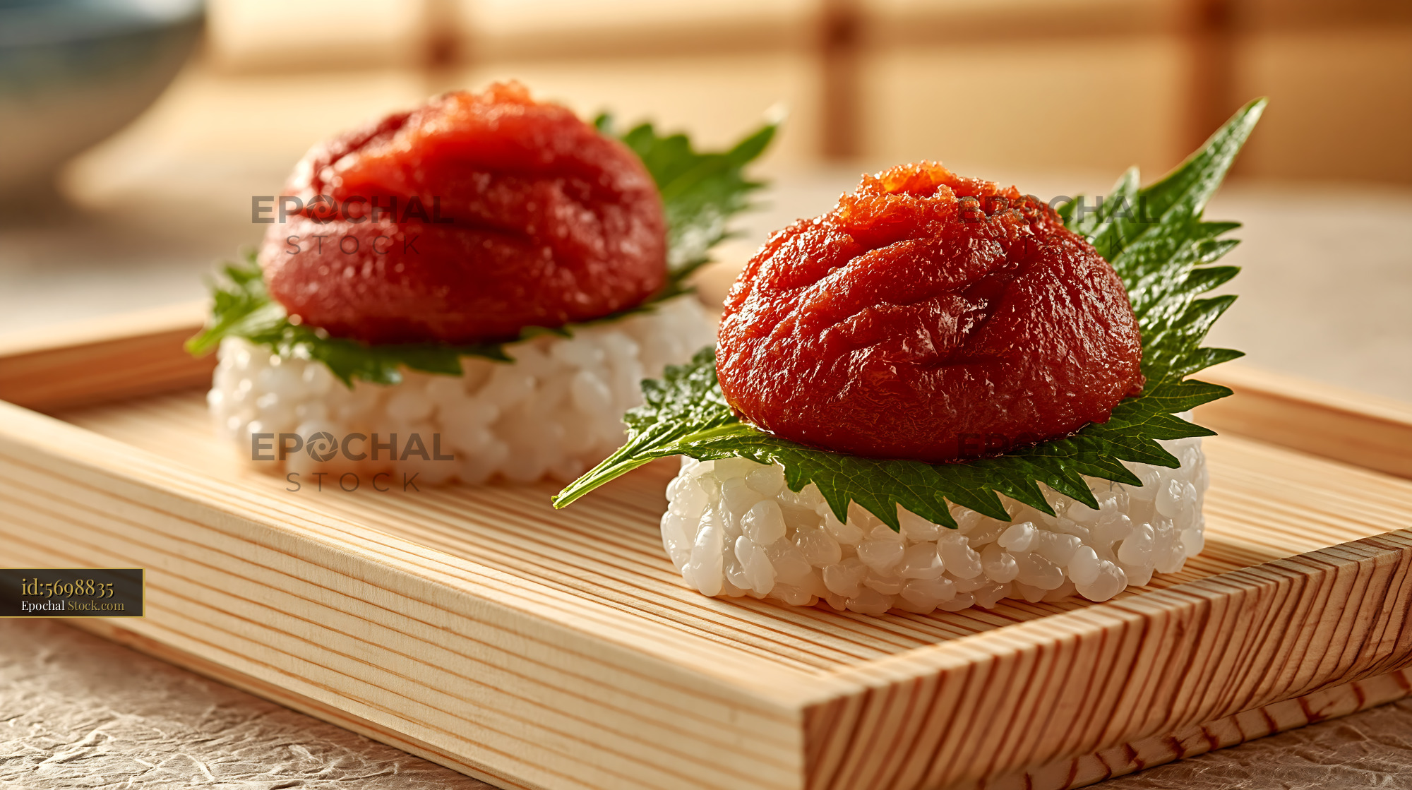 Traditional salted plum umeboshi sushi on wooden tray with shiso leaf - stock photo