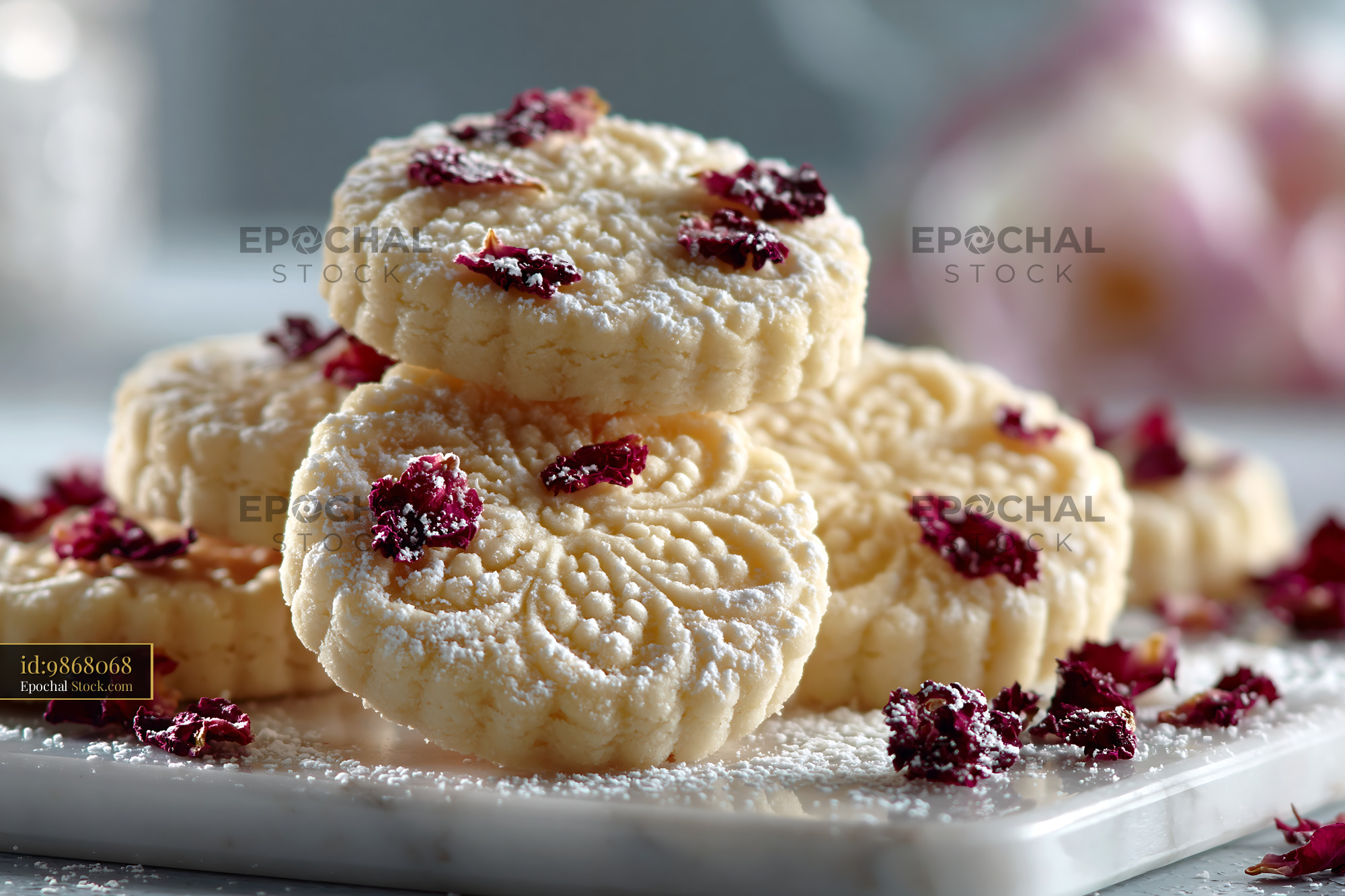 Stack of ornate rose water biscuits with dried petals and sugar - stock photo