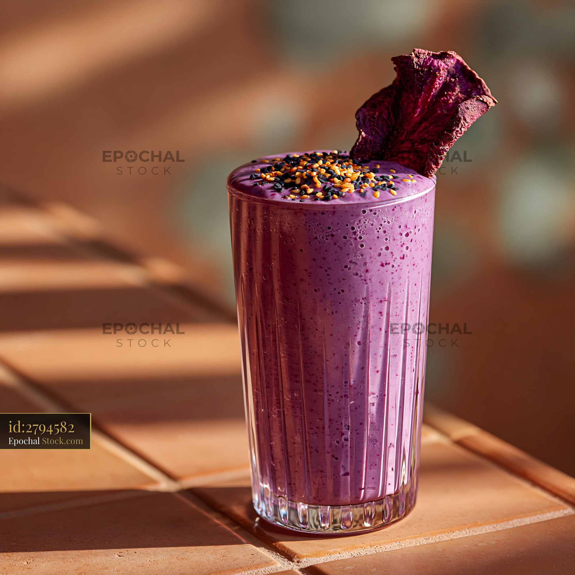 Purple sweet potato smoothie garnished with sesame seeds on tiles - stock photo