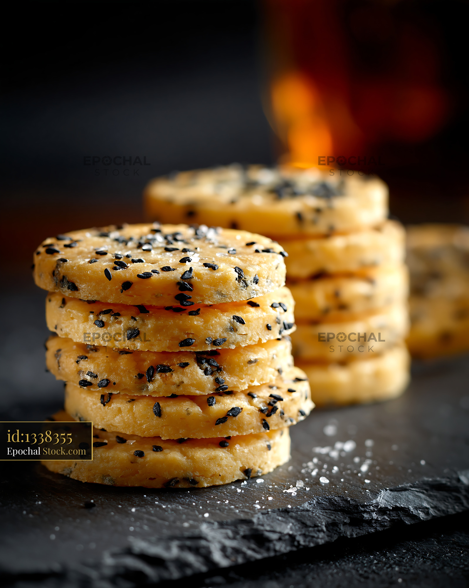 Stack of savory nigella seed biscuits with sea salt on dark slate - stock photo