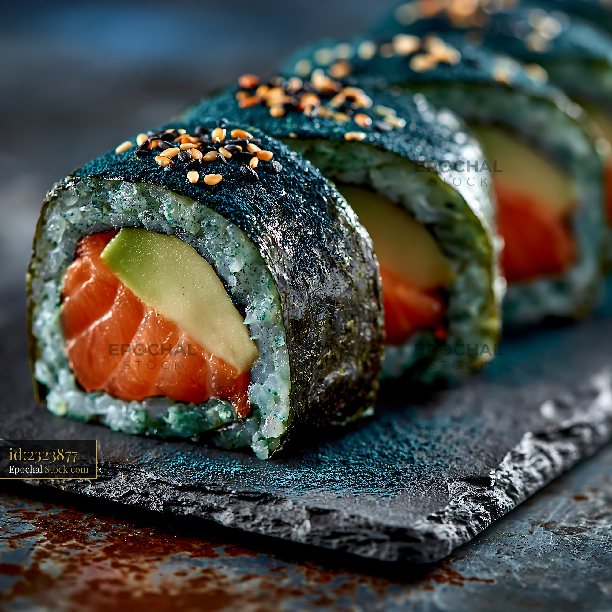 Spirulina powder sushi rolls with fresh salmon and avocado on slate - stock photo