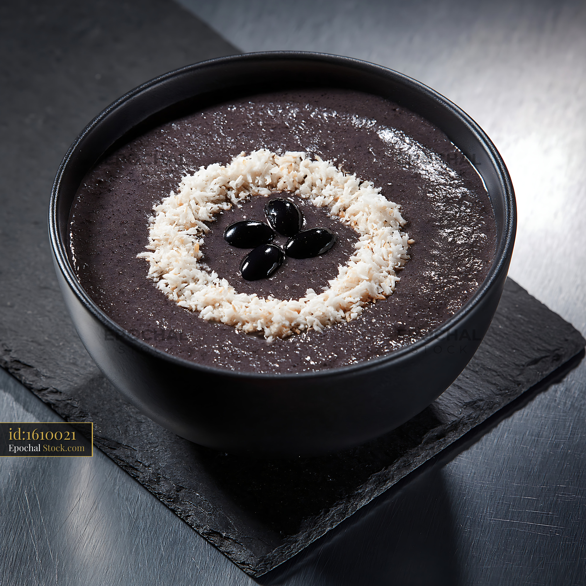 Healthy black bean smoothie bowl topped with coconut and beans - stock photo